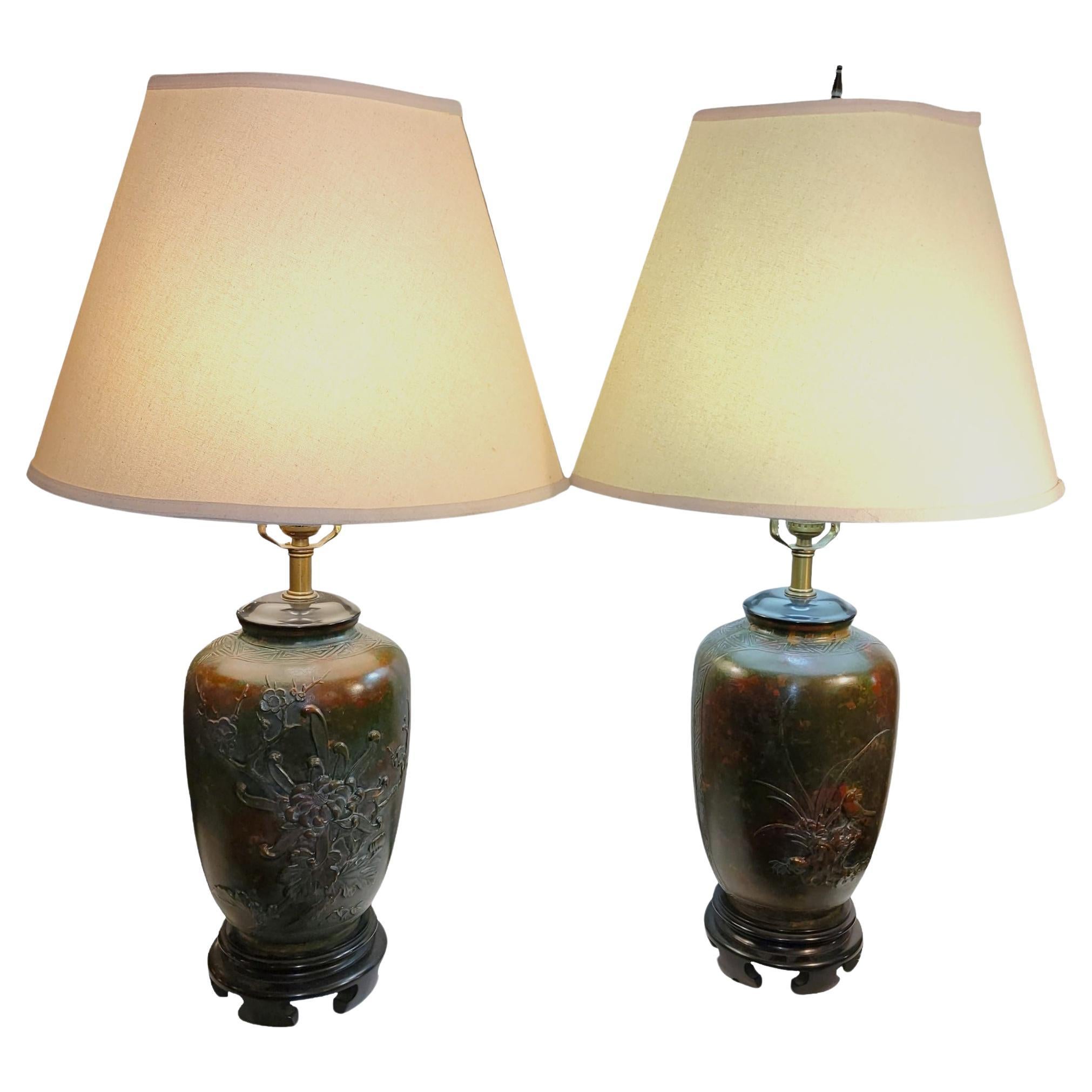 Pair of Marbo Los Angeles bronze table lamp. Floral and bird design with green and red colors throughout the entire design. Wonderful age and patina. Wooden dark brown base provides a touch of depth to the greens and reds. Both are in great working