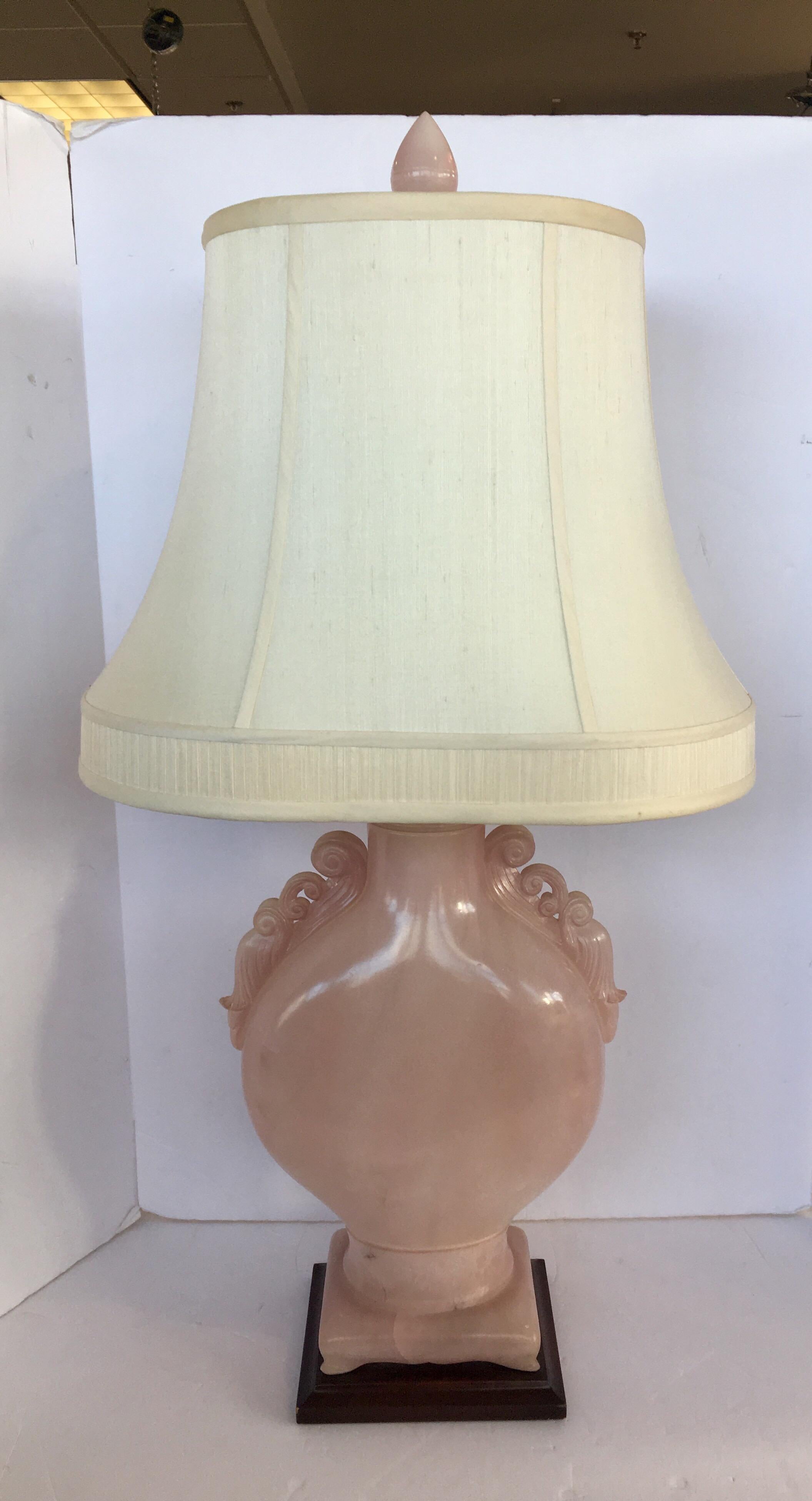 Pair of large, Asian influenced, solid pink alabaster lamps with pierced, faux armatures, matching foot and finial. Lamp sits atop a veneered, wood base. Made by the famed Los Angeles based, Marbro Company which closed it's doors in the 1990.
