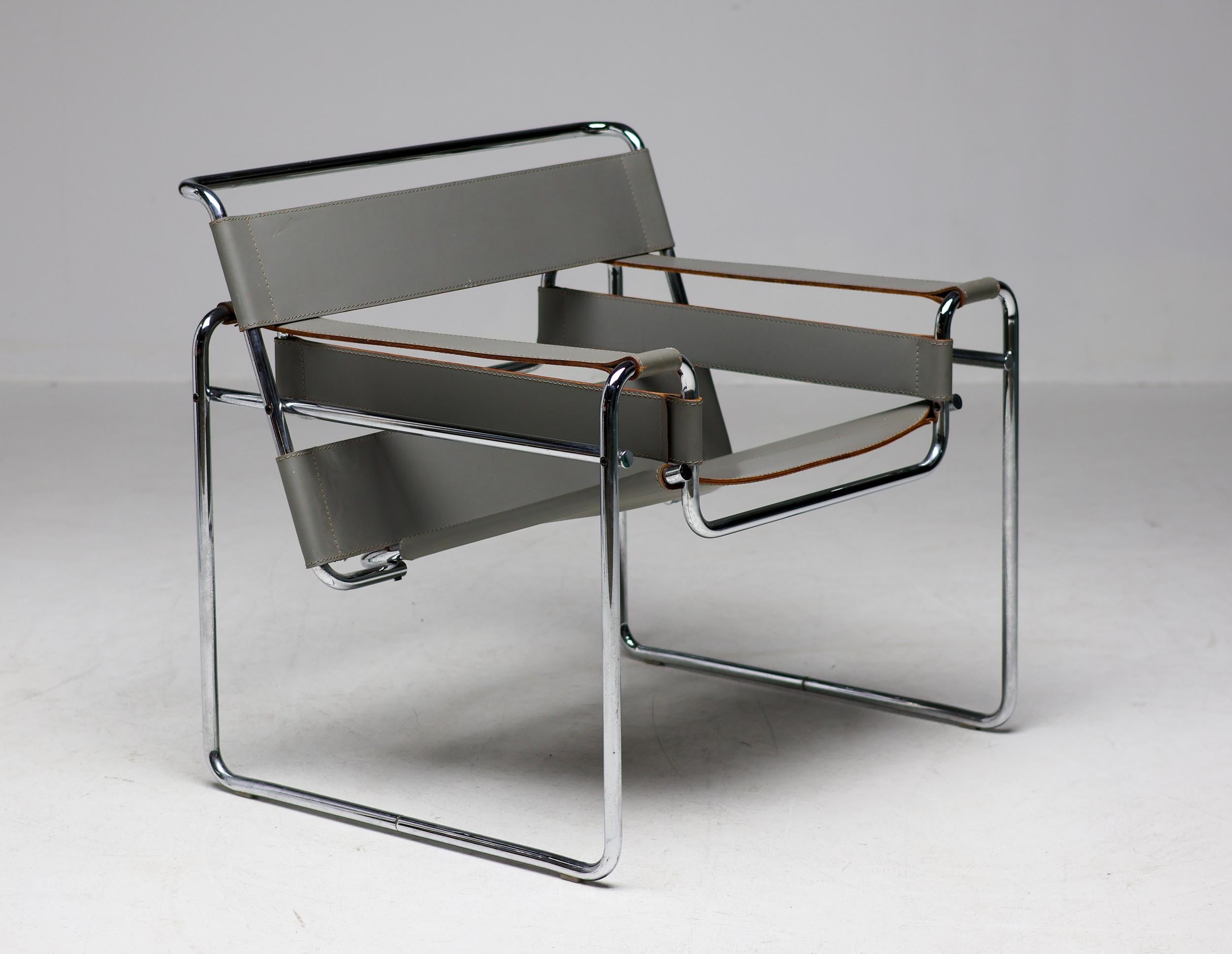 Unique early matching pair of all original grey leather Wassily chairs designed by Marcel Breuer, circa 1925. 
Manufactured circa 1960 by Gavina in Italy.  Made in grey leather with chromed tubular steel frame. 
The edges of the leather show the