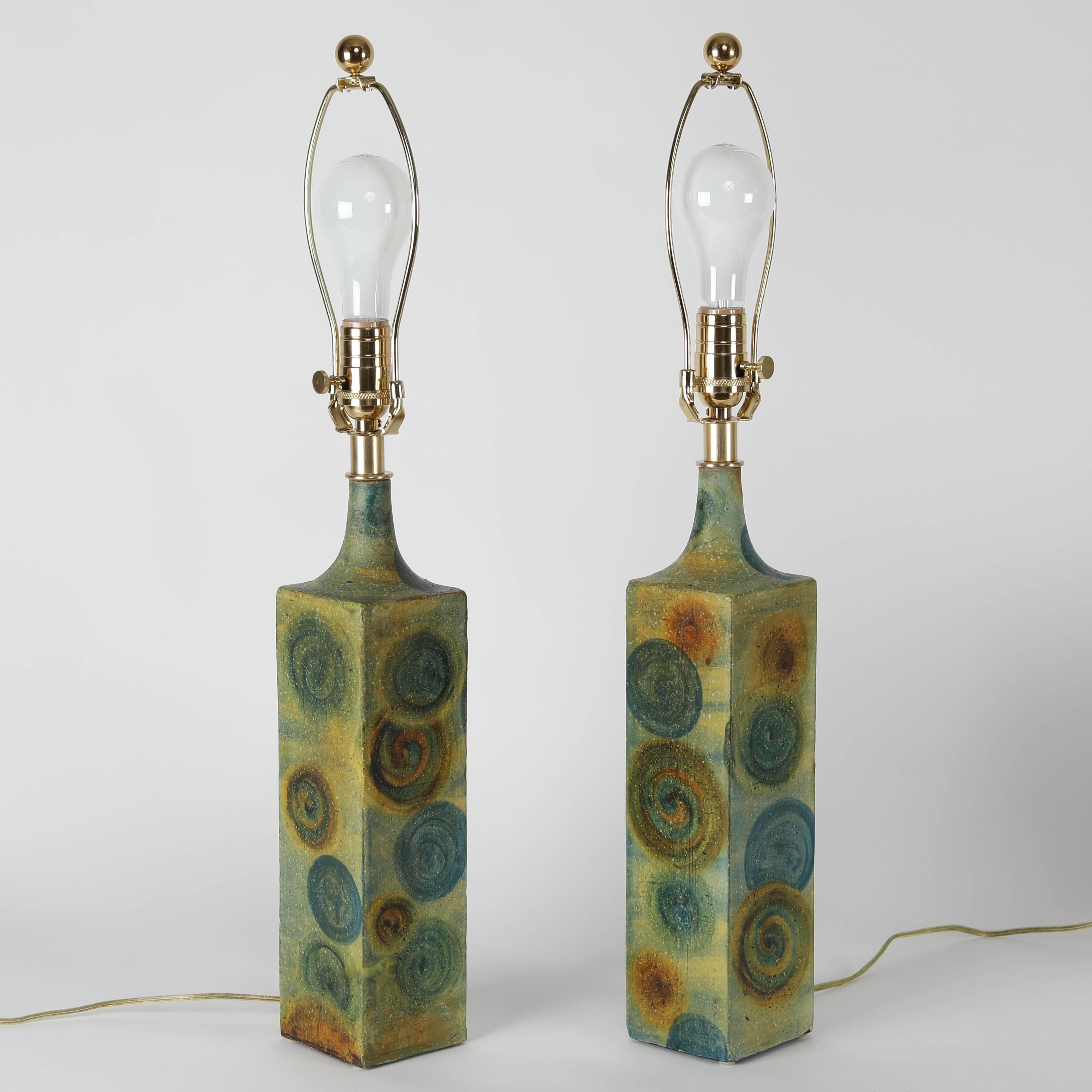 Fine pair of 1960s ceramic table lamps by noted Italian designer Marcello Fantoni. The square bases are hand-painted in blue-green and embellished with circles in blue and rust. Three-way switch on neck; standard-base socket. New polished-brass