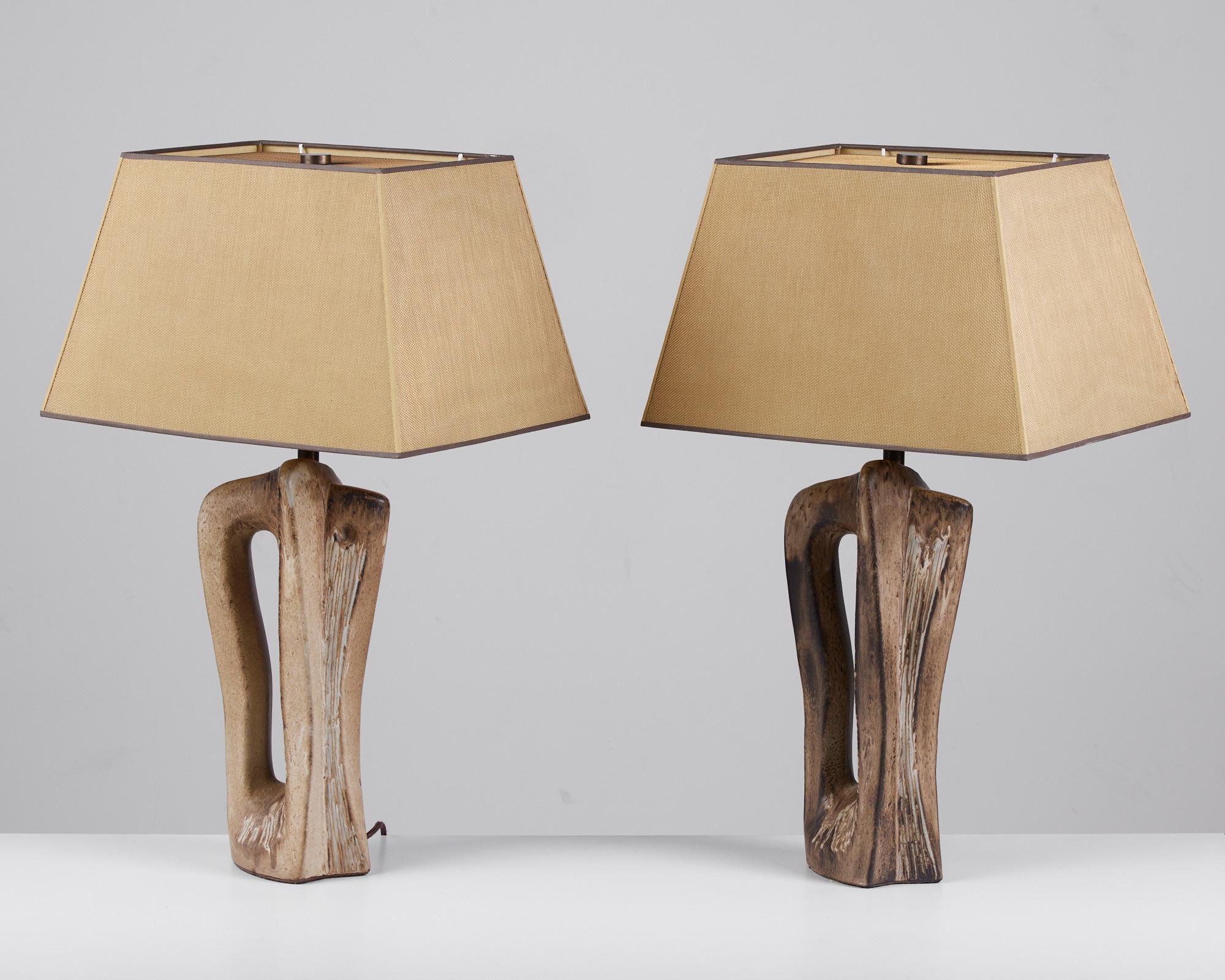 Pair of striking ceramic lamps by German born designer and ceramicist Marianna Von Allesch, c.1950s, USA. These lamps feature an abstract ceramic base with brown and tan glaze. The lamps are finished with custom trapezoidal brass mesh-overlay