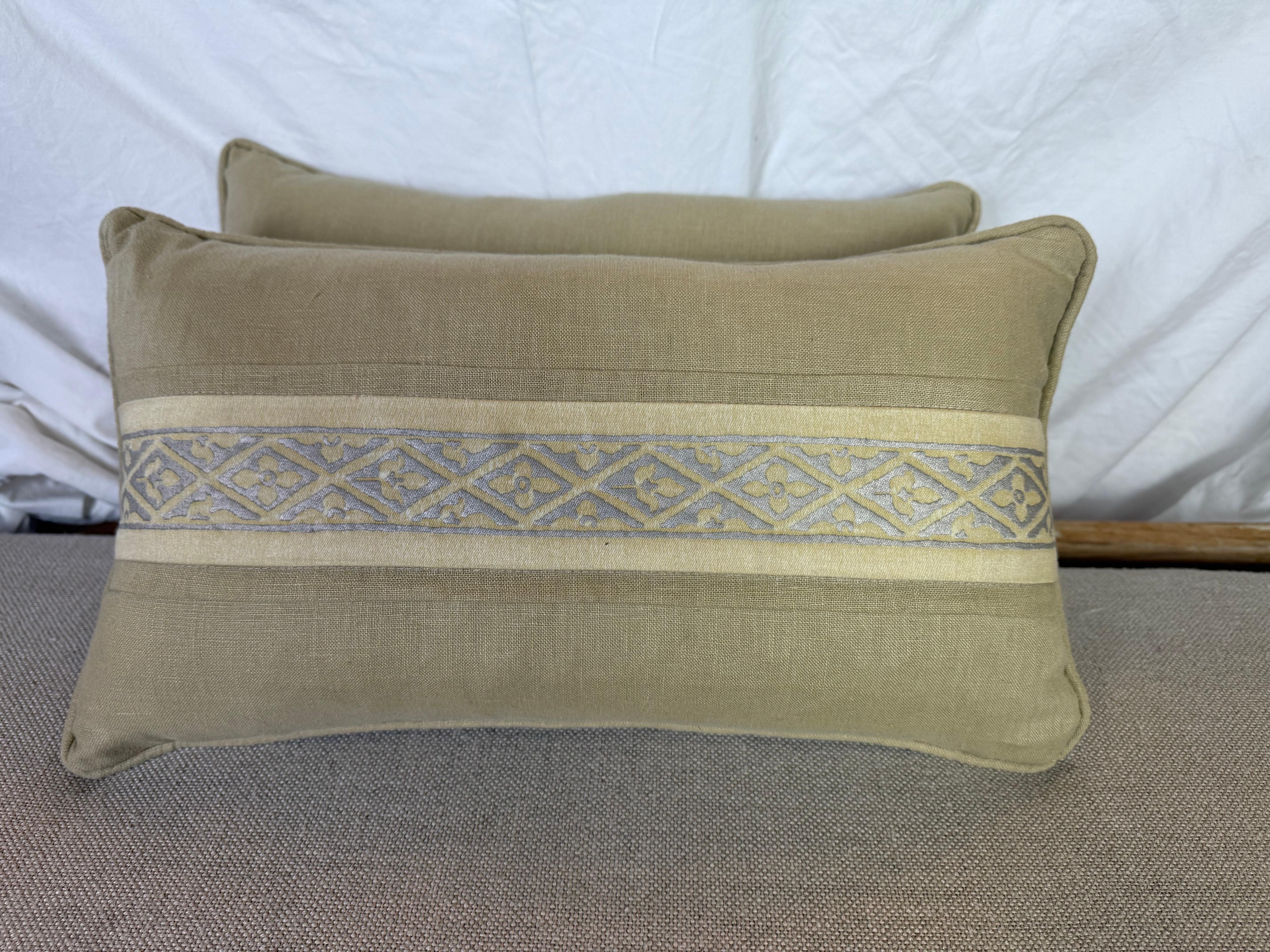 Questi eleganti cuscini presentano una sofisticata miscela di texture e motivi. Sono realizzati in tessuto di lino di alta qualità, che funge da sfondo neutro e sottilmente strutturato, permettendo al raffinato accento tessile di Mariano Fortuny di