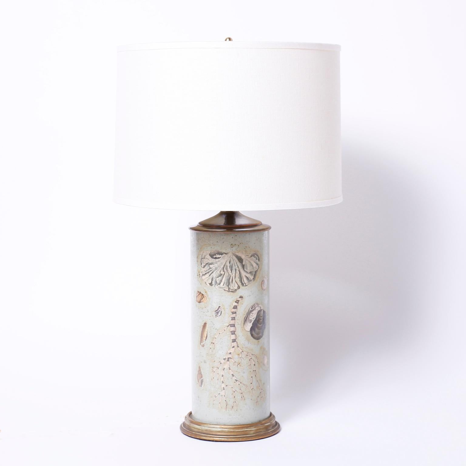 Unique pair of glass cylinder table lamps with marine shell and sea life inspired reverse elgomise decoupage against a sea green background.