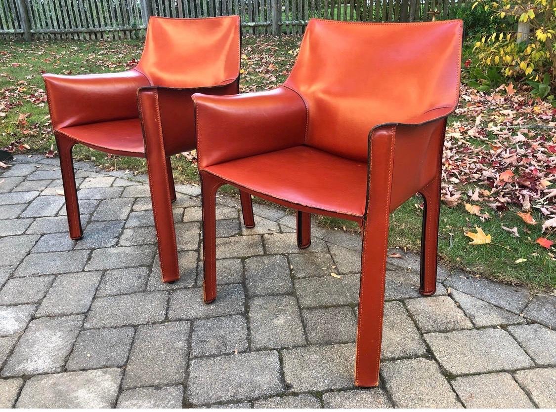 Coveted pair of Mario Bellini cab armchairs designed for Cassina in the 1980s.
Wrapped in a rare thick cognac saddle leather and beautiful exposed stitching trim. Rare
to see 413's in such great condition. All dimensions are below and armrest