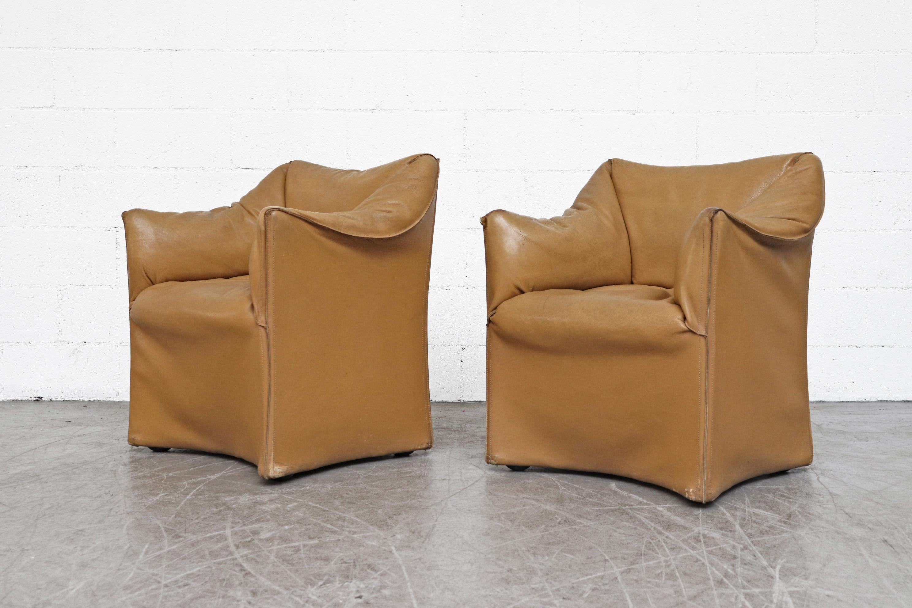 Pair of Mario Bellini Caramel leather armchairs. Distinctive wing style armrests. In very original and worn condition with visible wear and patina. Well loved, set price.