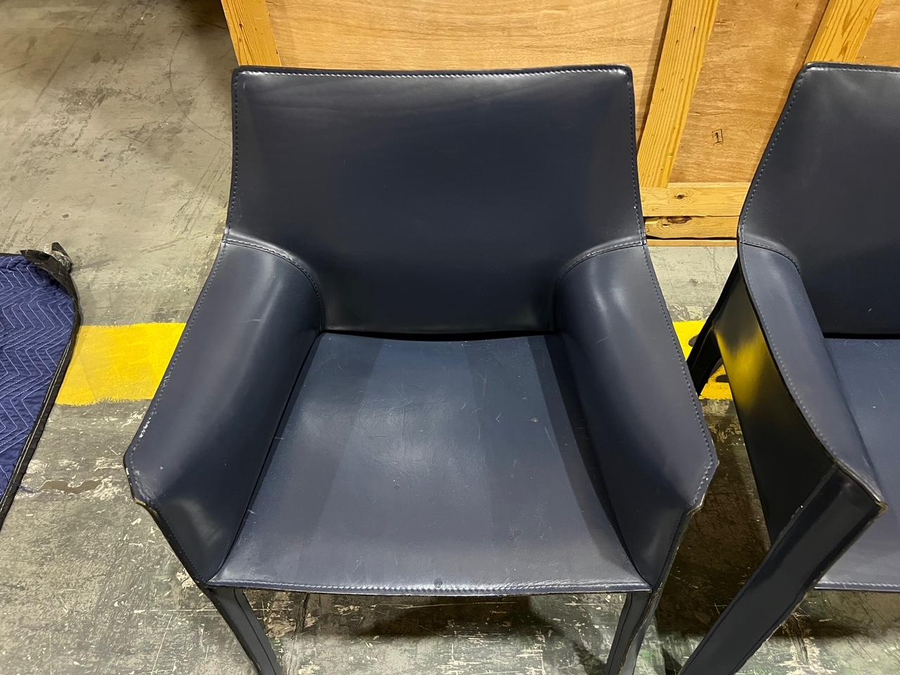 Pair of Mario Bellini for Cassina 'CAB 413' Dining Chairs in Navy Blue Leather.
A pair of captain chairs with arm-rests. When first produced in 1977, the CAB was the first chair to feature a free-standing leather structure, inspired by how human