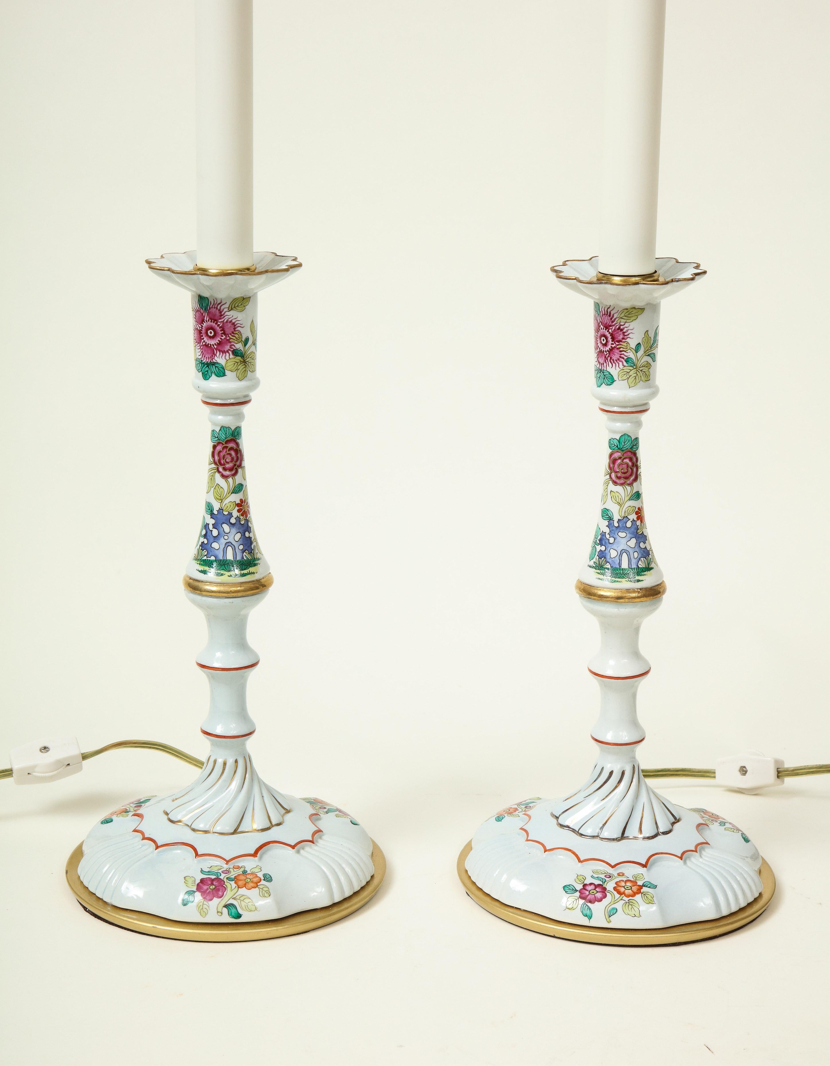 Each with candle sleeves supported by white enameled and gilt metal candlesticks decorated with floral sprays. Lamps designed by Mario Buatta for Frederick Cooper.
 
