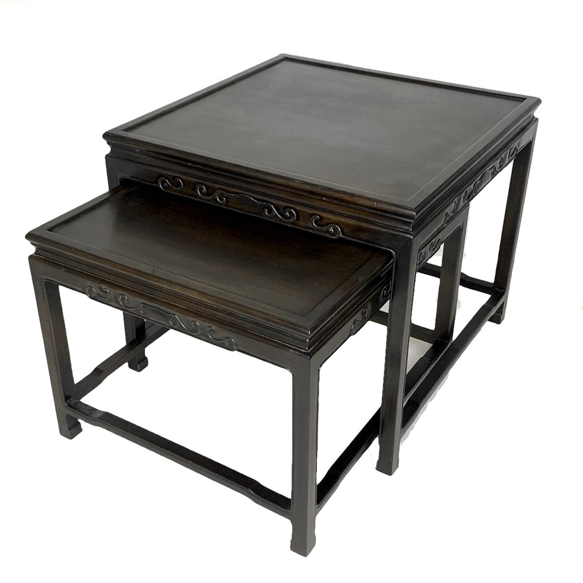 Decorative pair of very usable solid nesting tables with a subtle decorative chinoiserie style. These tables also function well independently. Constructed of ebonized mahogany. Finish shows as a deep dark mahogany- almost black depending on