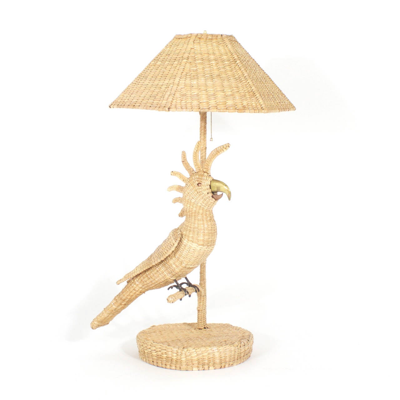 Pair of Mario Torres table lamps depicting cockatoos perched on a branch with brass and copper beaks and copper eyes. Constructed of a metal frame tightly wrapped in wicker or reed with matching wicker shades. Signed Mario Torres Established 1974 on