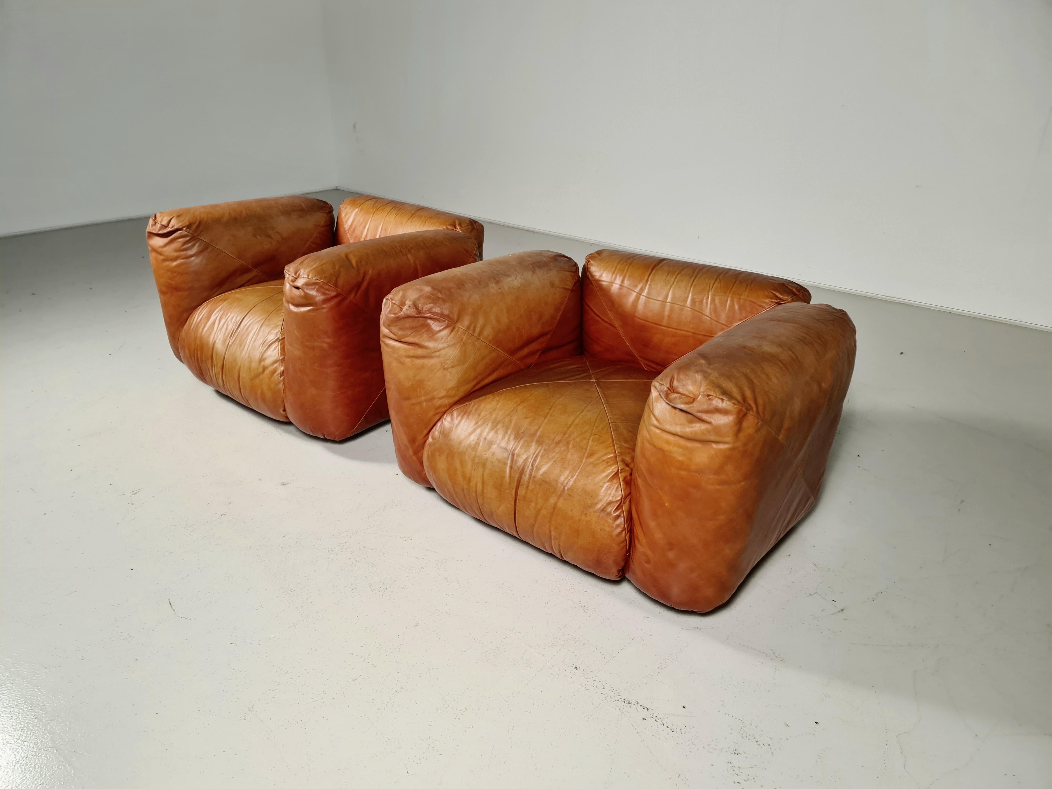 Pair of Cognac leather lounge chairs produced by Arflex in the 70s. Designed by Mario Marenco. Wooden base. The seat, back, and armrests are made of padded cushions. We also have a matching 3-seater sofa available.