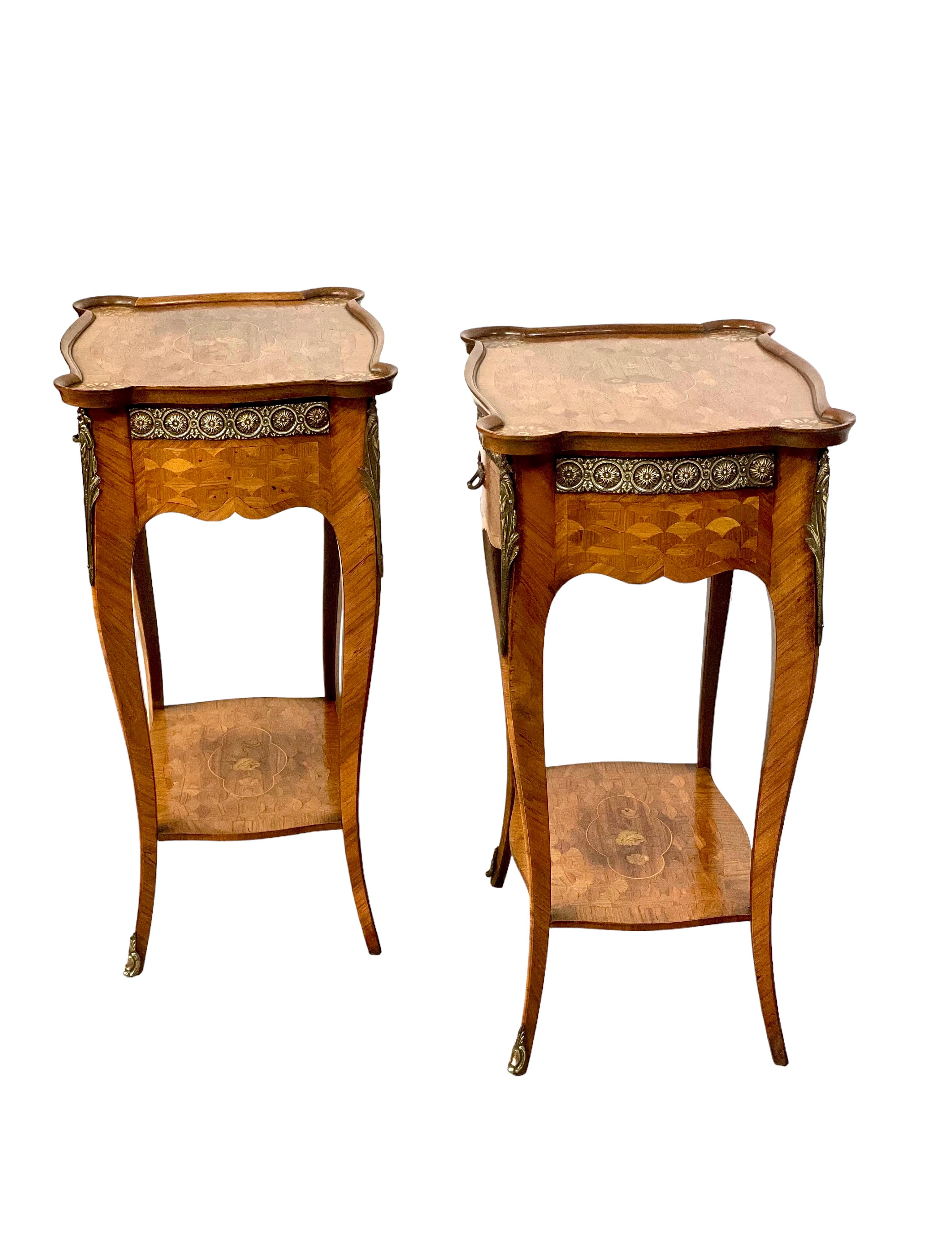 A delightful pair of Louis XV-style side tables in delicate veneered wood, with decorative marquetry inlaid detail on all sides. These tables are a lovely 'bombe' shape, standing on elegantly curved cabriole legs, which support a suspended lower