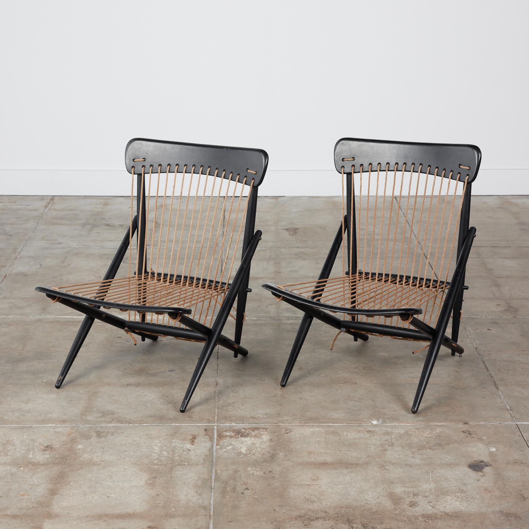Pair of Maruni rope lounge chairs, circa 1950s, Japan. The chairs feature an ebonized beech wood frame and are contrasted by their camel tension roped seat and seat back. These minimalist chairs have to look of a folding seat but are in a set
