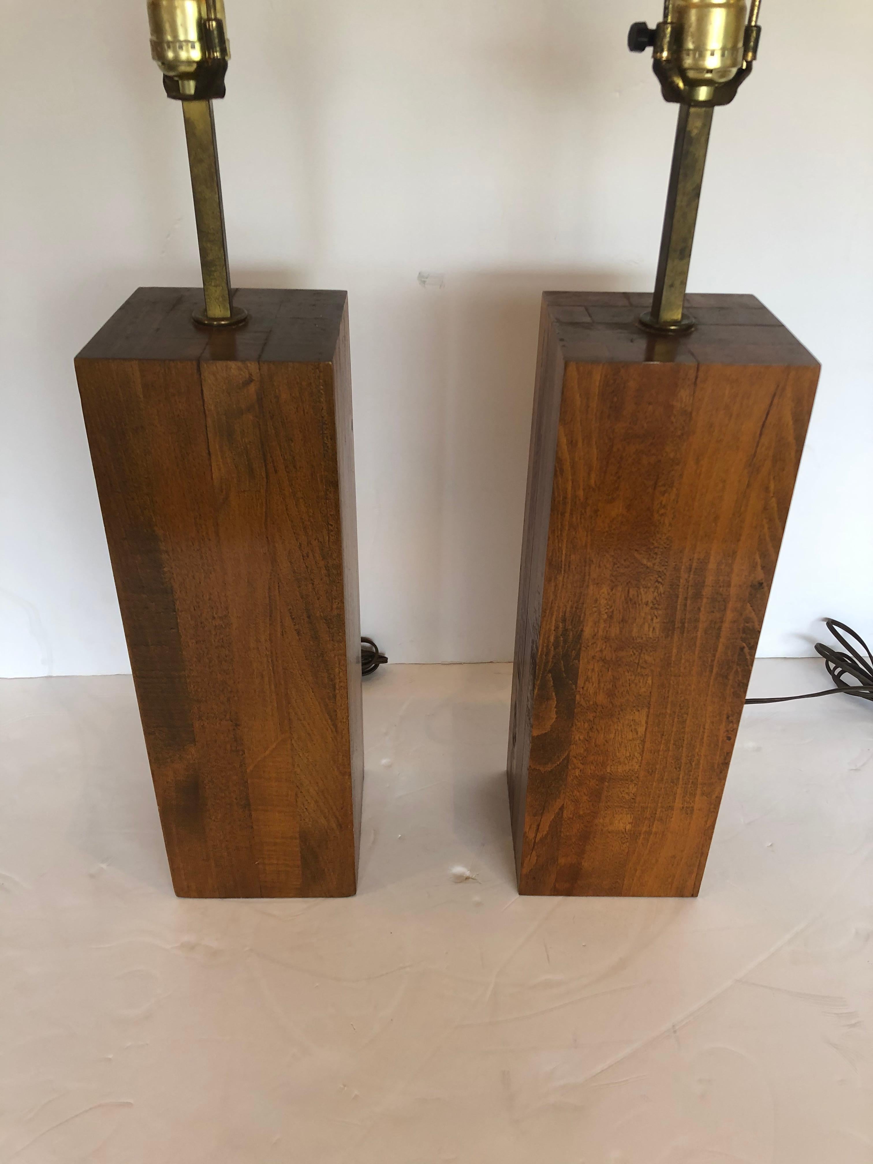 A beautifully crafted pair of sculptural black walnut block form table lamps having 5 