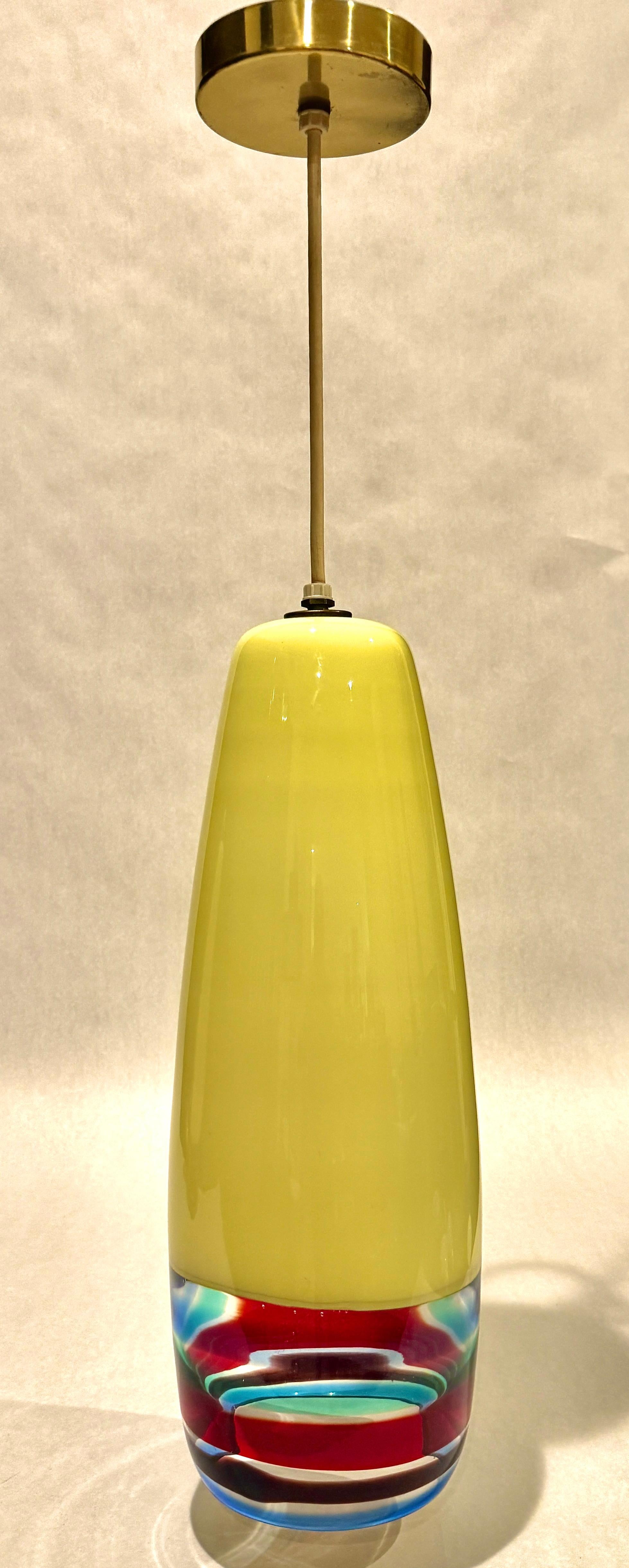 A rare large and vibrant pair of Murano glass table lamps designed by Massimo Vignelli for Venini, dating to the 1960s. These sculptural lamps feature a sleek, elongated silhouette with a softly tapered form in luminous canary yellow glass. The base