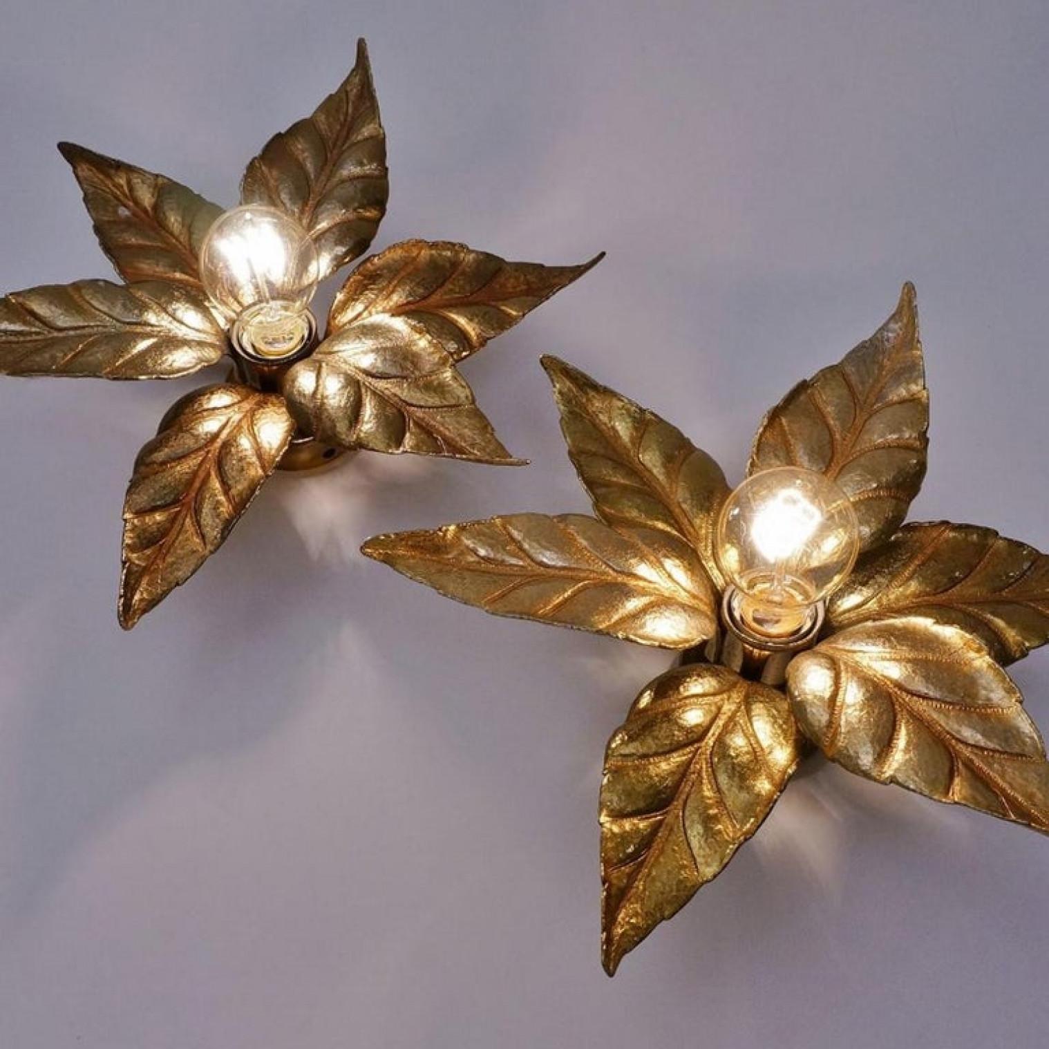 Two very nice massive flower wall lights, made in Belgium in the 1970s. In a style reminiscent of designs by Willy Daro. These lights are made of brass and look like a life-size big flower, very nice sculpted in brass.

The golden brass reflects in
