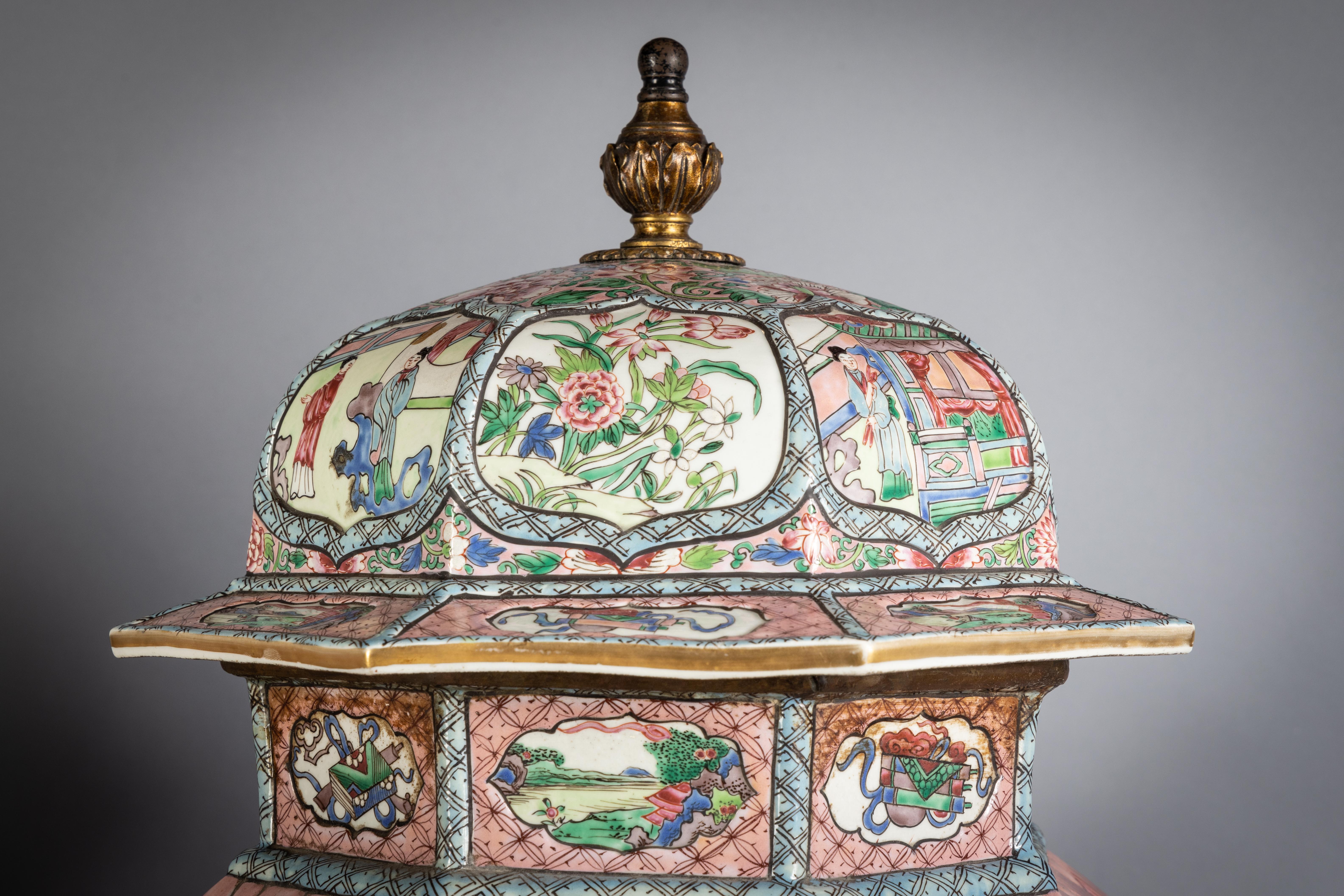 Finely enameled in a Famille Rose palette, the octagonal panels alternating with floral and figural decoration, the attached covers with a bronze finial, mounted on a wood base, circa 1875.