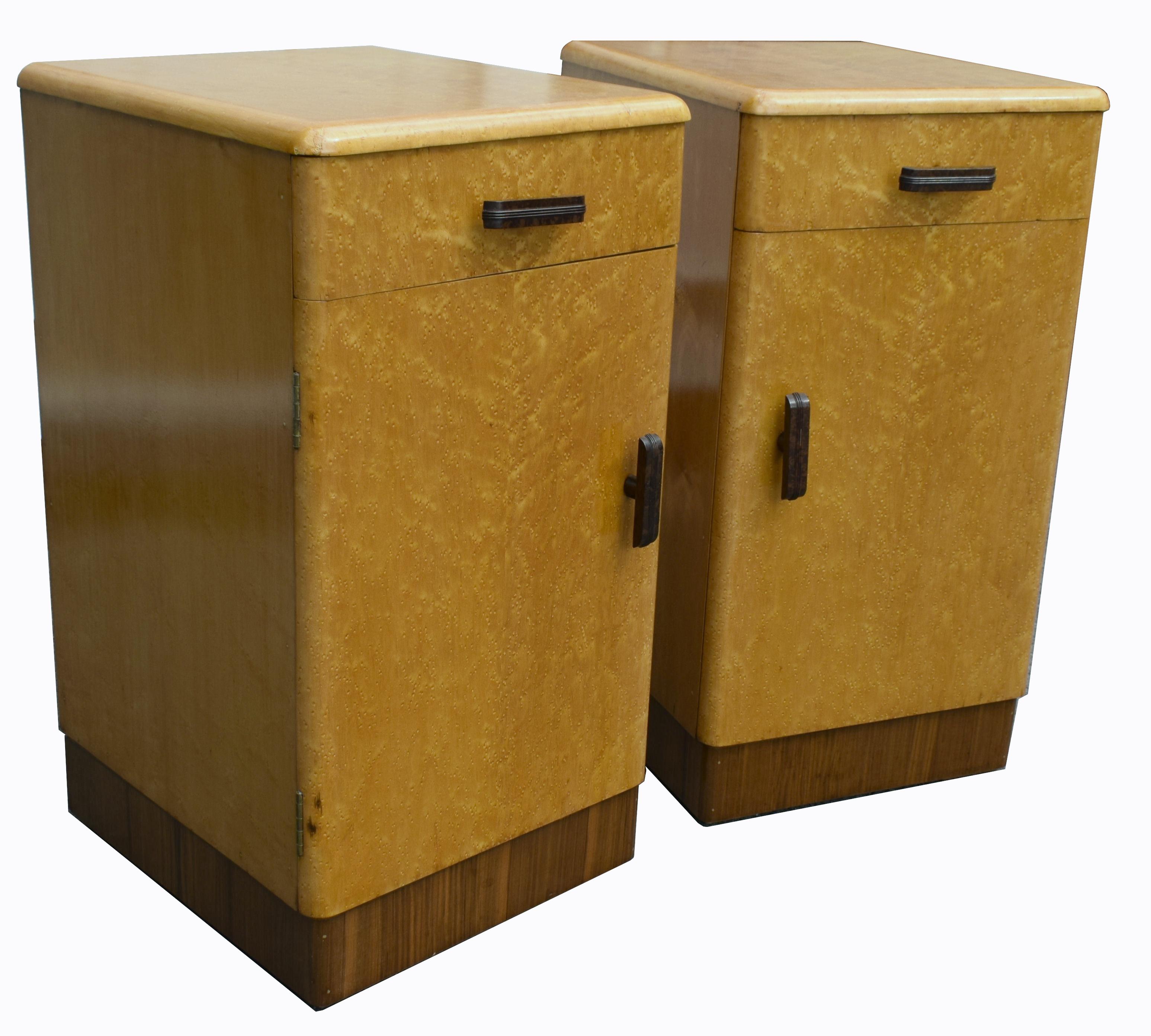 Fabulous pair of matching 1930s Art Deco bedside cabinet tables in a lovely blonde bird's-eye maple and walnut veneer. These cabinets originate from England and feature a pull out / pull-out drawer to the top which retains its original Bakelite