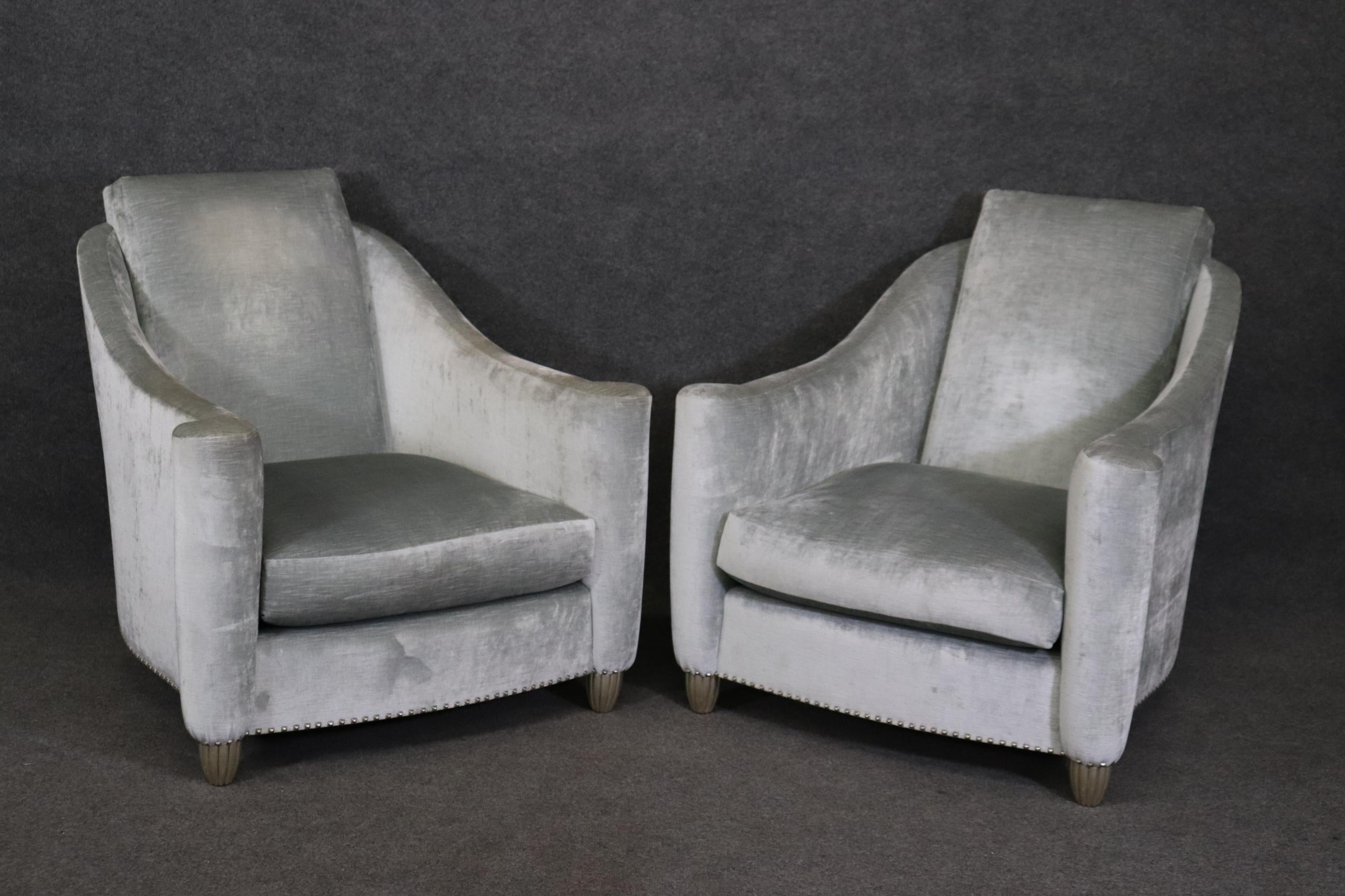 This is a stunning pair of silver-gray velvet upholstered club chairs with matching ottomans. The chairs are absolutely gorgeous and in good used condition. I did not see any stains but they are used and may have some slight or minute stains that I