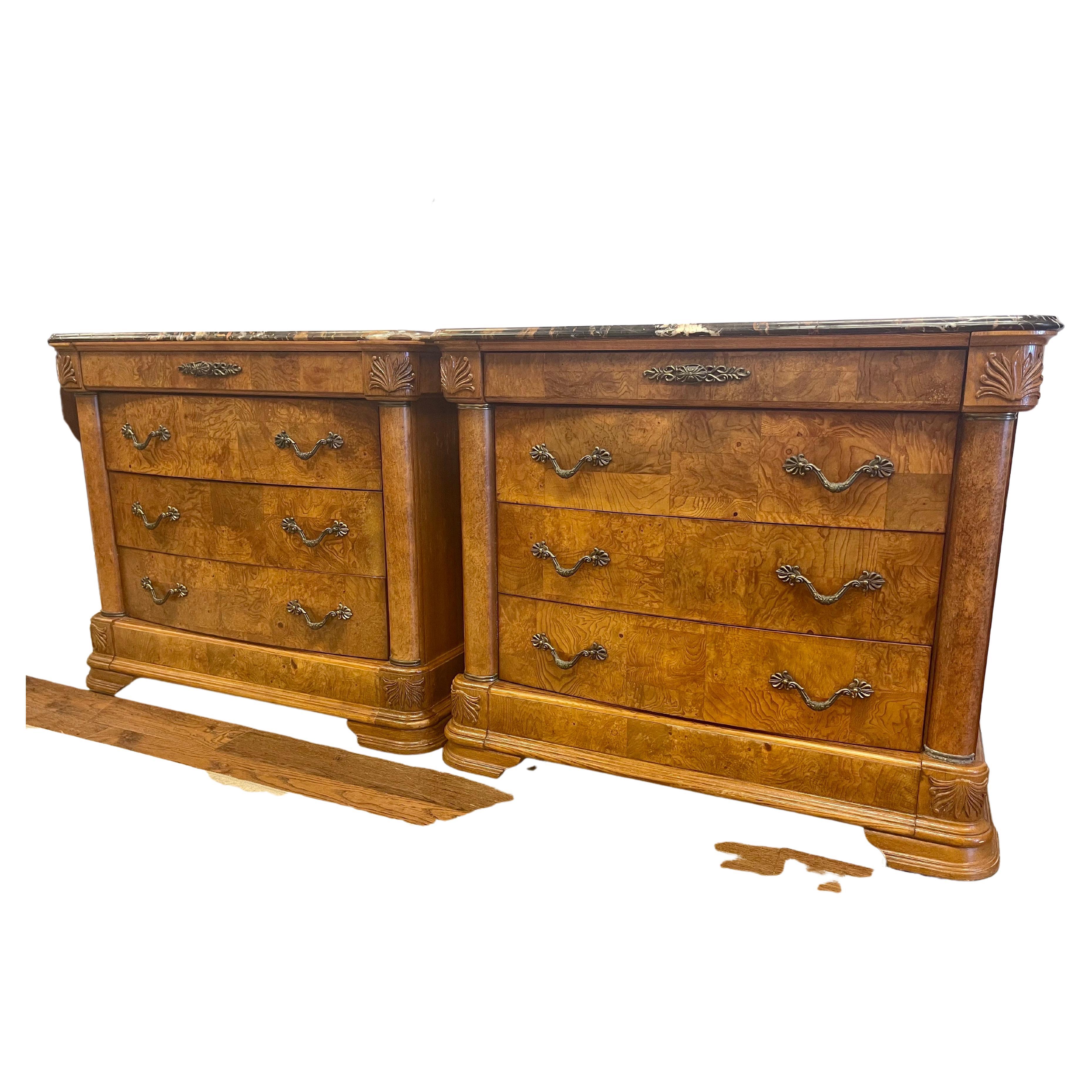 Elegant pair of marble top American Drew four drawer dressers featuring three larger drawers at bottom and one smaller drawer at top. Walnut body with beautiful graining; original metal reticulated hardware and gorgeous marble tops with brown and