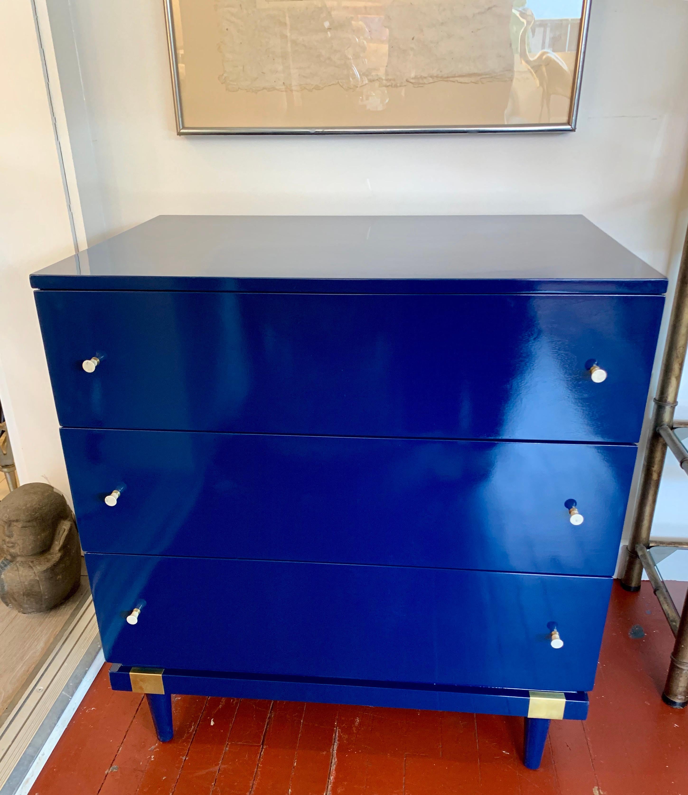 Newly refurbished pair of matching lacquered Raymond Loewy designed small chests of drawers.
The color is a deep blue with gold accents. They are nothing short of magnificent.