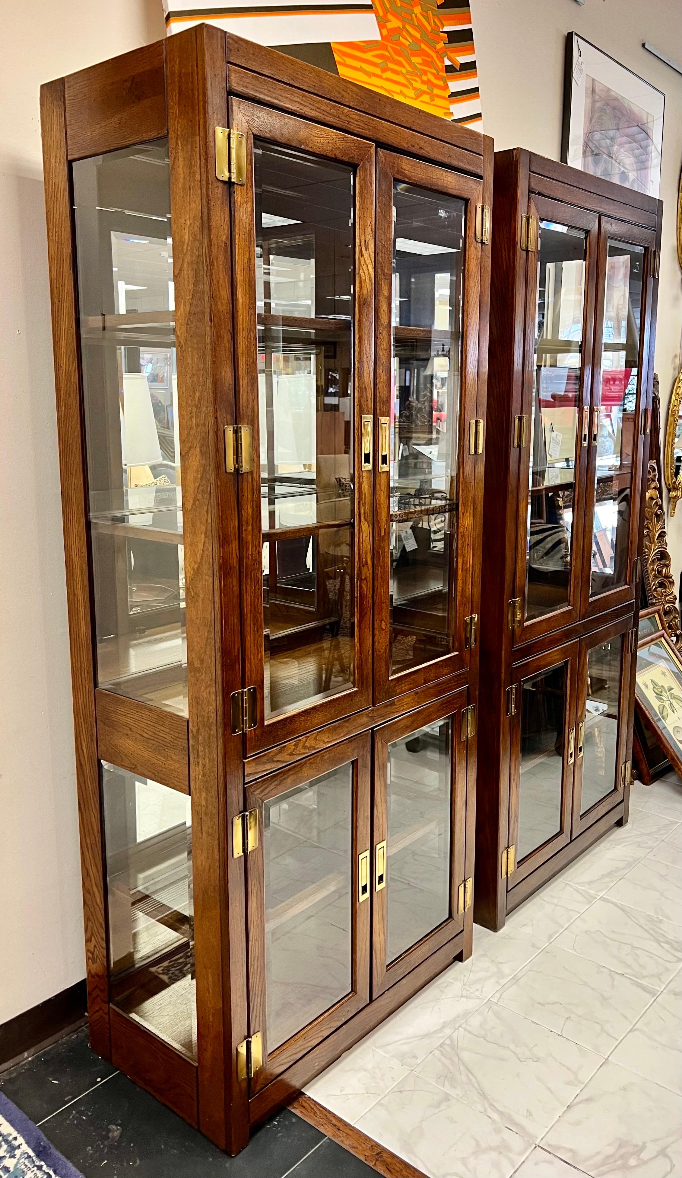 Coveted pair of Mid-Century Modern vitrines that feature doors art top and bottom. All original. Although they are electrified the lighting has not been tested and we do see a loose wire - again, not an issue an electrician couldn't fix if needed.