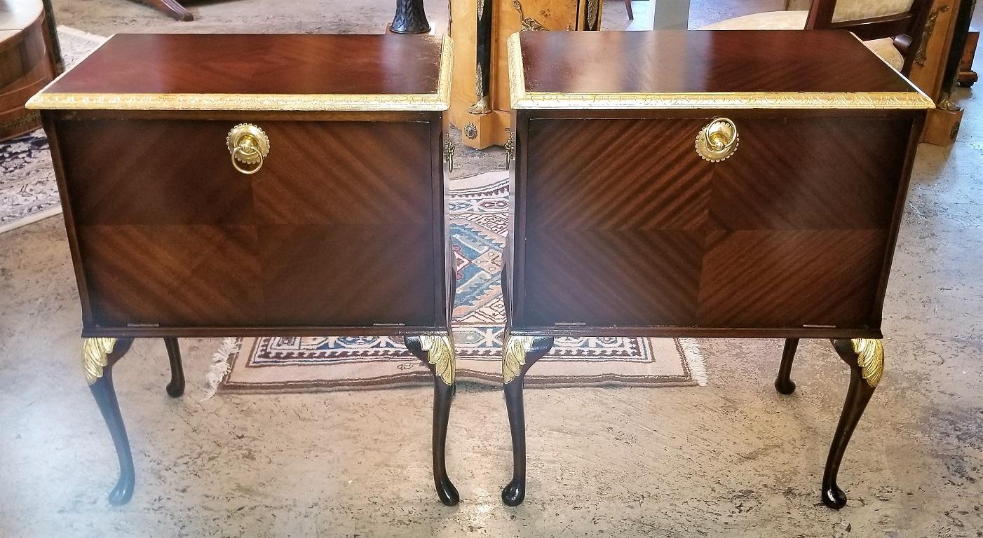 Presenting a lovely pair of matching side tables or nightstands with gilt accents.

British, circa 1920.

Originally, these mahogany tables would have been ‘music cabinets’…..designed for holding records.

Made of mahogany, they have a gorgeous