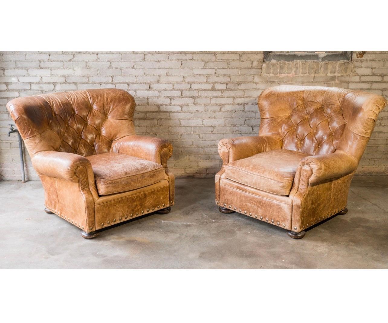 Pair of Tufted leather writer's club chairs presented in a beautifully distressed cigar leather. Reminiscent of Ralph Lauren writer's chair. Brass nailhead trip, removable seat cushion, tufted leather backrest. Nice patina, good springs and foam.