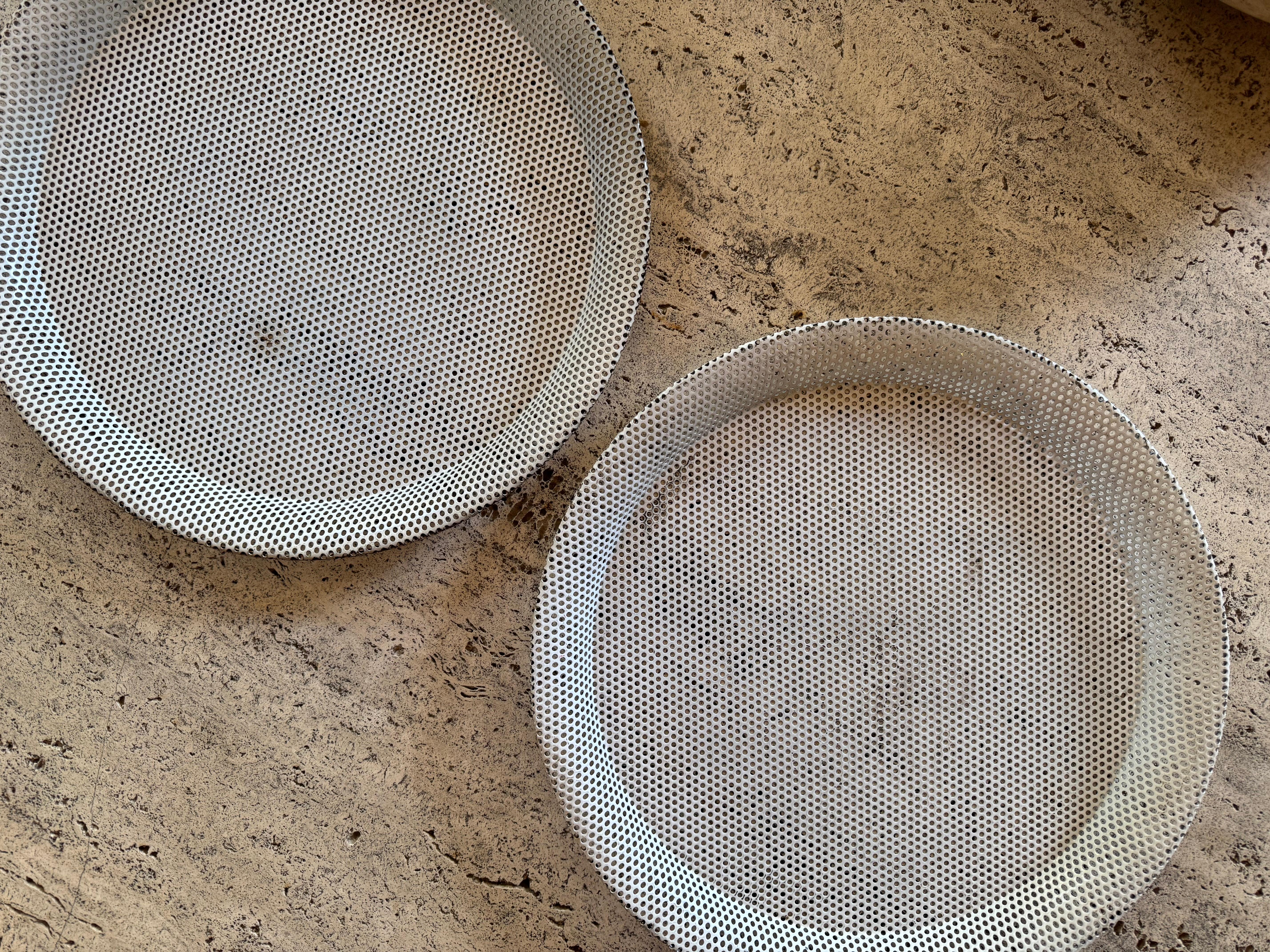 Coppia di vassoi originali in metallo verniciato bianco traforato di Mathieu Mategot, 1955 circa. Vernice originale. Alcuni piccoli segni di ruggine e ammaccature.