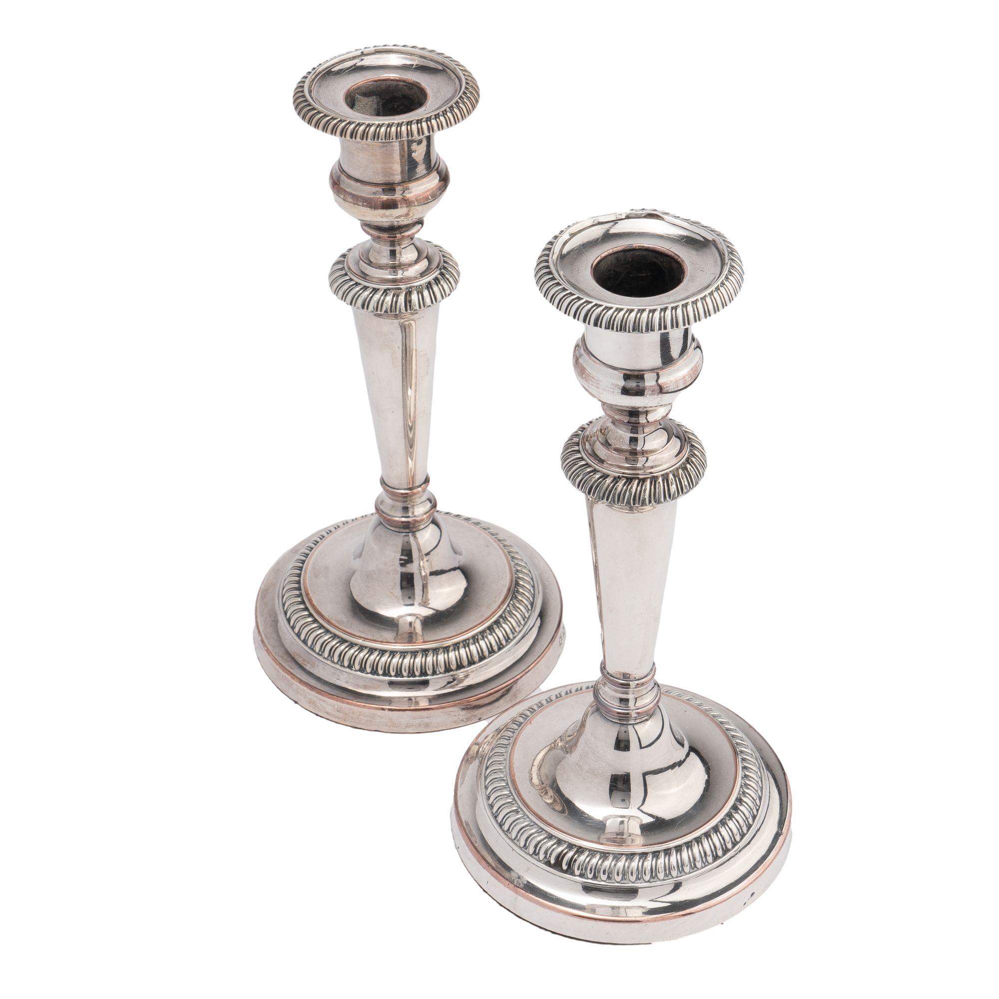 Pair of Matthew Bolton Sheffield candlesticks with a gadrooned bobeshe and base with tapered conical shaft. Both candlesticks feature the makers stamp of two stars on the side of the base.

England, circa 1815.
