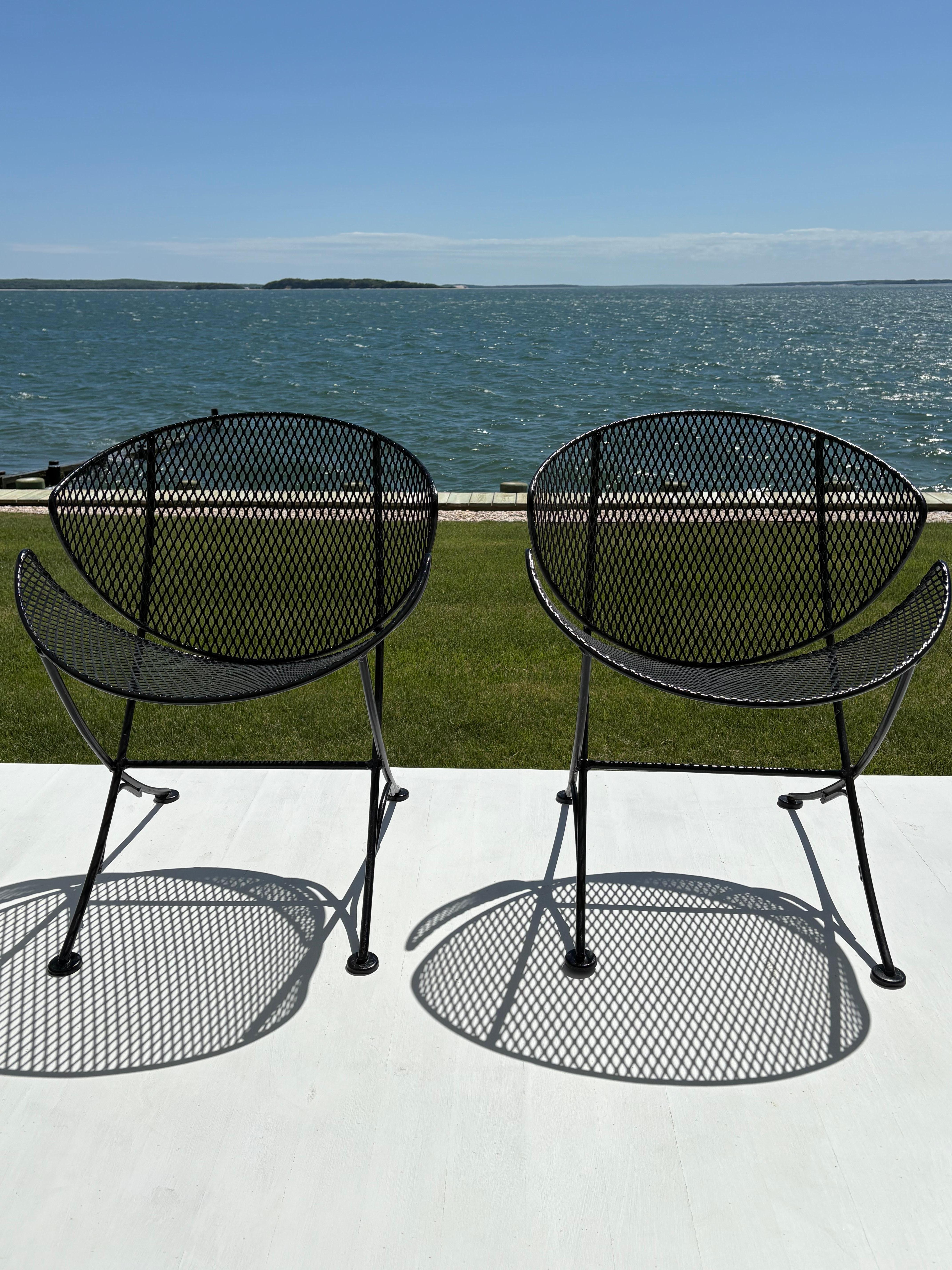 Great looking pair of Maurizio Tempestini Clamshell or Orange Slice patio chairs by Salterini . This coveted wrought iron chic design can be for indoor or outdoor use . The chairs are metal mesh over iron rod legs and capped feet . They are painted