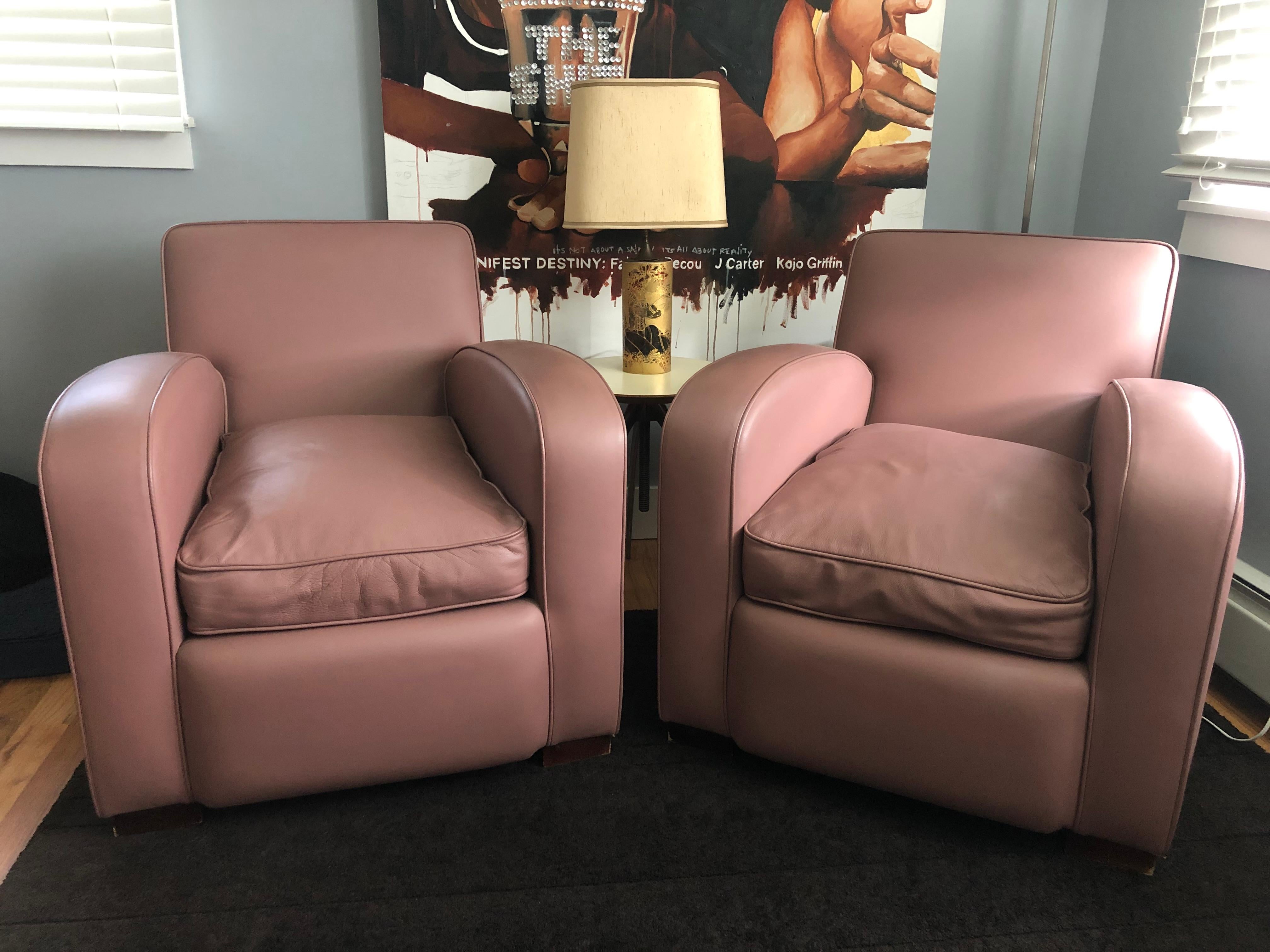 Elegante paire de fauteuils club en cuir mauve. Fabriquées sur mesure au Royaume-Uni, ces chaises allient les styles moderne et Art déco, offrant une esthétique unique, à la fois chic et polyvalente. Les chaises sont dotées d'un dossier à angle