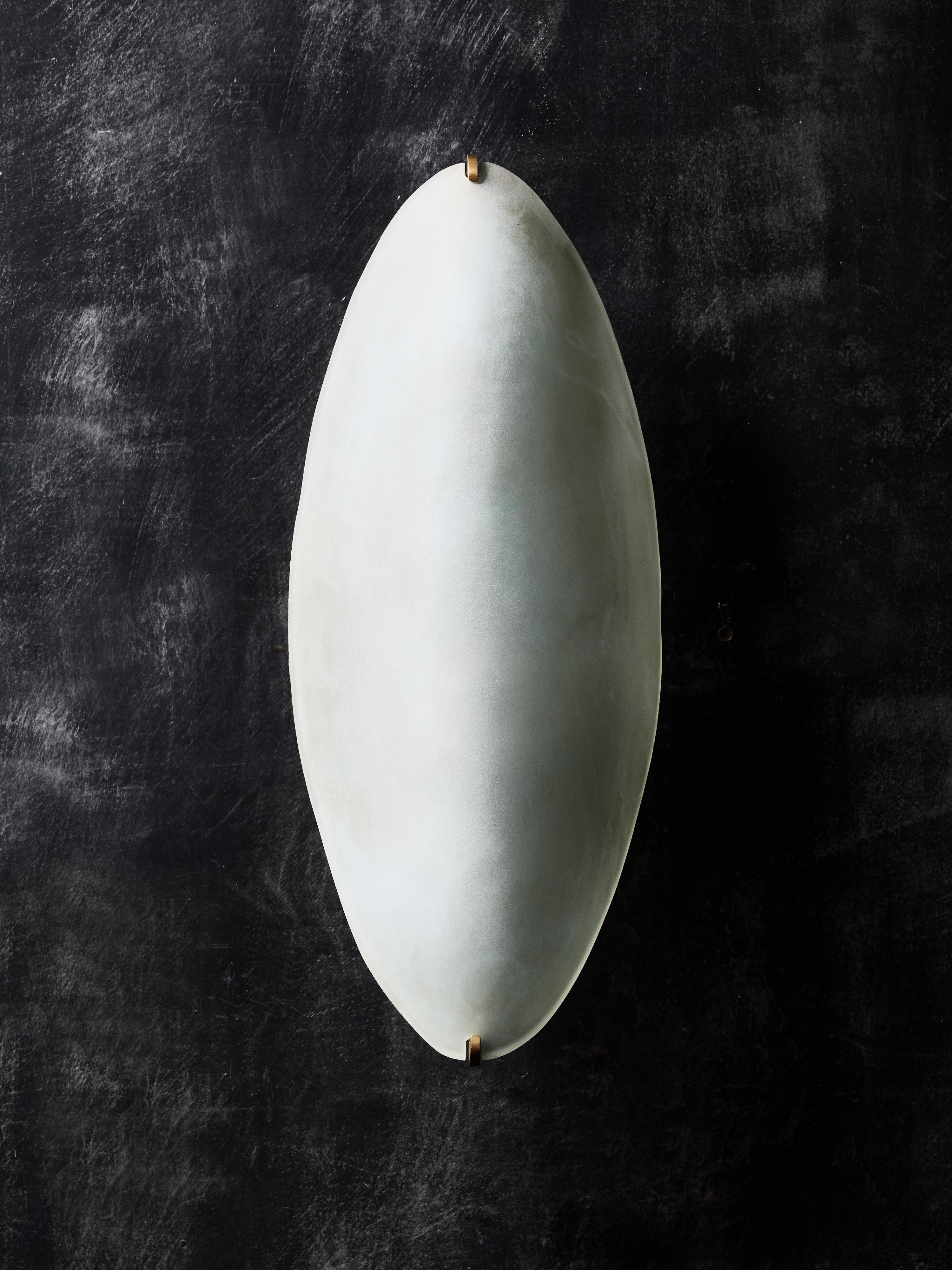 Exquisita pareja de apliques de pared Modelo 2024 diseñados por Max Ingrand para Fontana Arte en la década de 1950. Estas elegantes luminarias incorporan el cristal escultural característico de Ingrand: un difusor satinado alargado en forma de