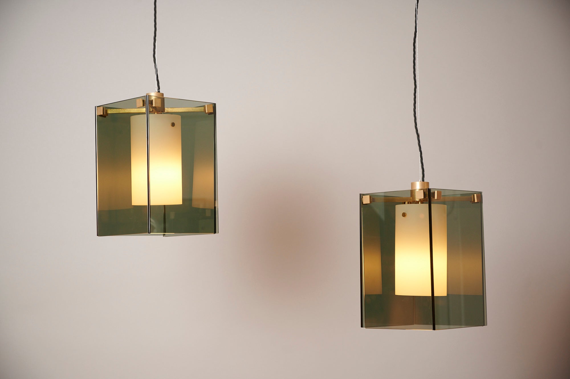 A pair of Max Ingrand Model 2211 pendant lights. 

Dark grey glass encloses a white glass cylinder for diffused light. 

The drop is currently at 100cm but can easily be adjusted. 

Glass is in excellent condition and there is a nice patina to the