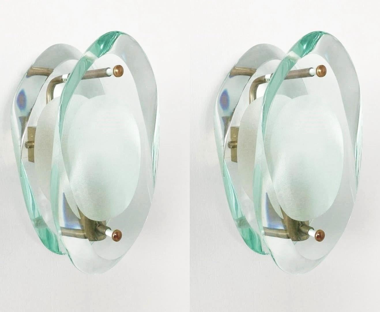 A pair of wall lights sconces by Max Ingrand for Fontana Arte, Model 2093, Italy, 1960-1961. Organically shaped double lens cut panels of of thick profiled polished Murano glass with sandblasted centers, brass mounted. The Model 2093 is one of the