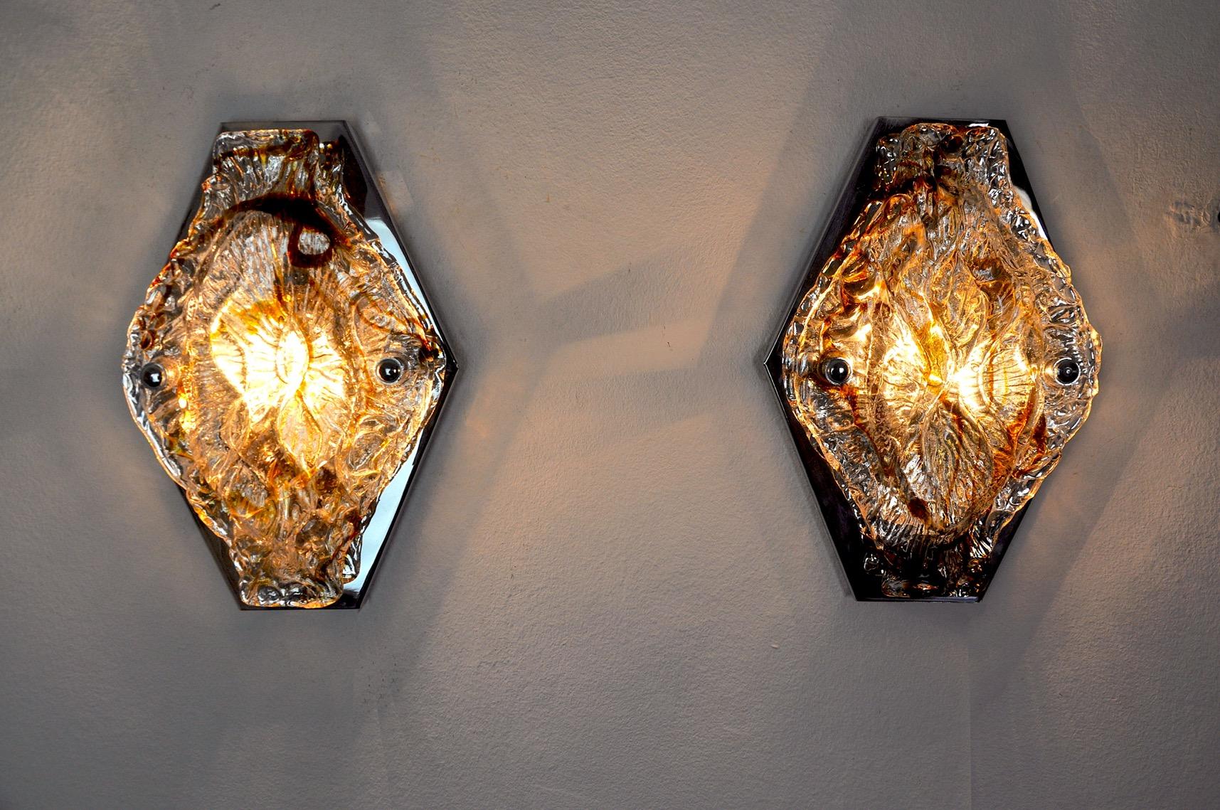 Very beautiful and rare pair of murano mazzega sconces designated and produced in italy in the 1960s.

Composed of an orange murano glass crystal and a chromed metal structure.

Unique object that will illuminate wonderfully and bring a real