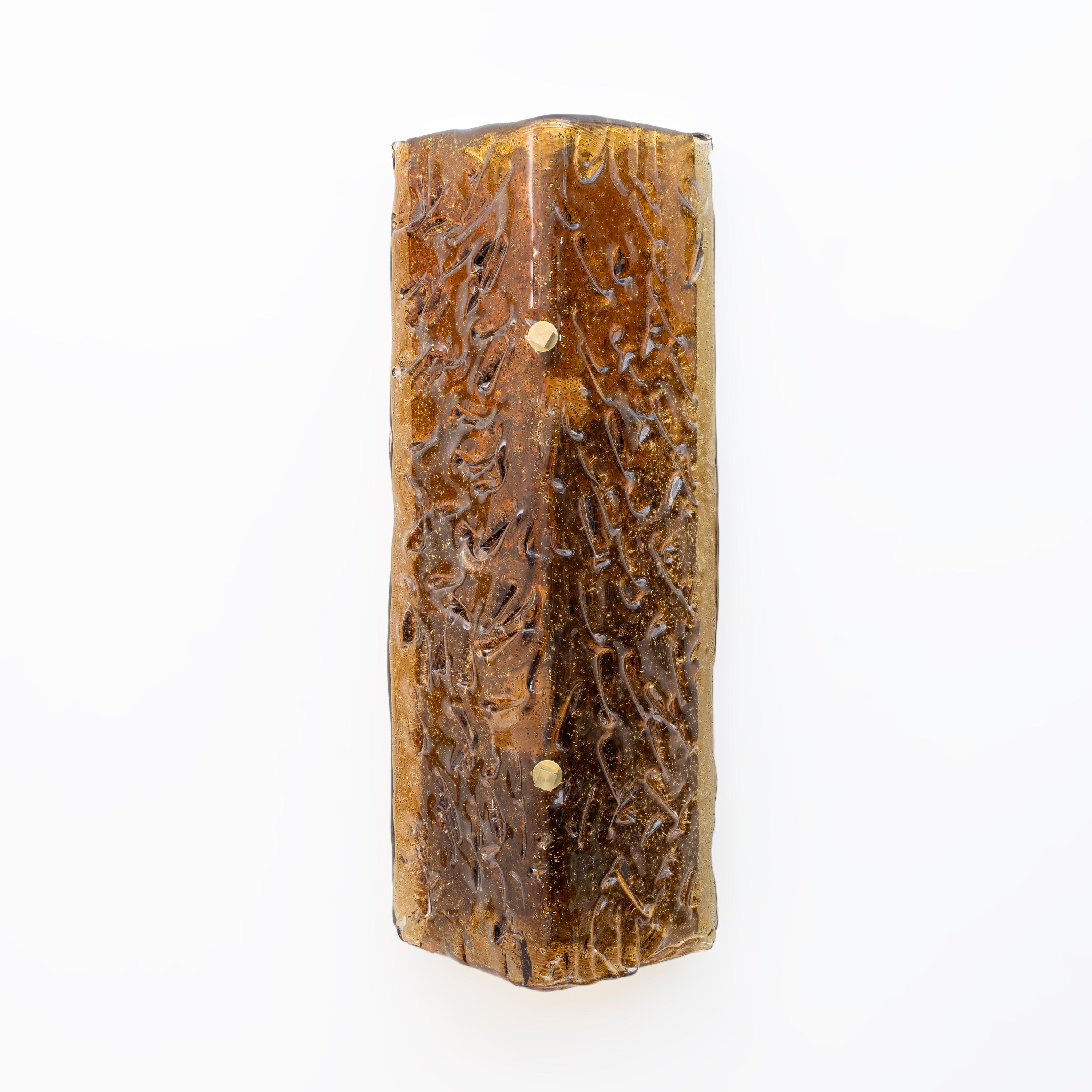 Pareja de apliques con un diseño único y artístico. Las lámparas están hechas de cristal de Murano ámbar con escamas de oro en el interior, la superficie se caracteriza por texturas intrincadas, el cristal es muy grueso y pesado, el cristal está