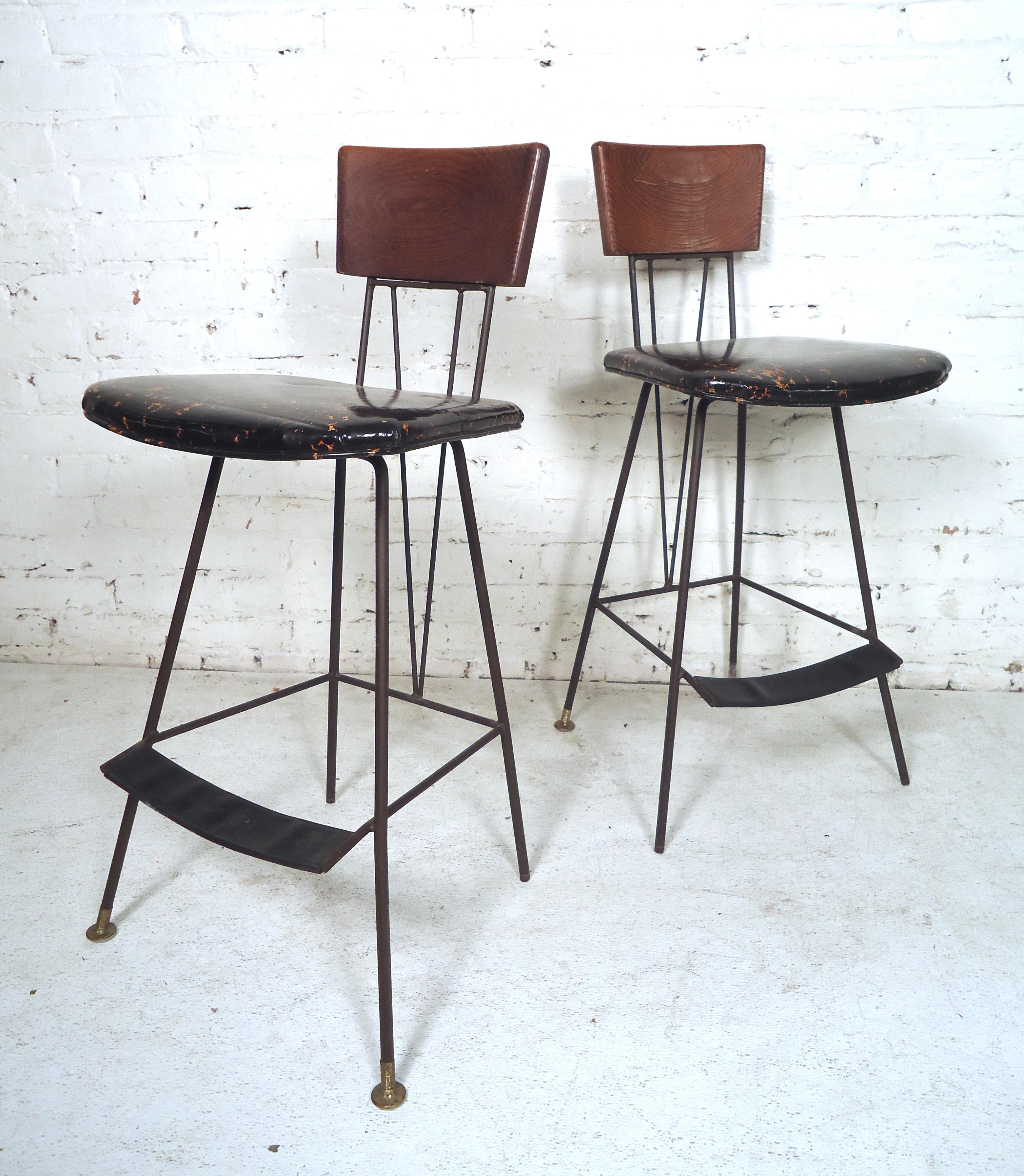 Gorgeous pair of Paul McCobb style stools features wood backrest, cushioned vinyl seating, and wrought iron legs.

Please confirm item location (NY or NJ).