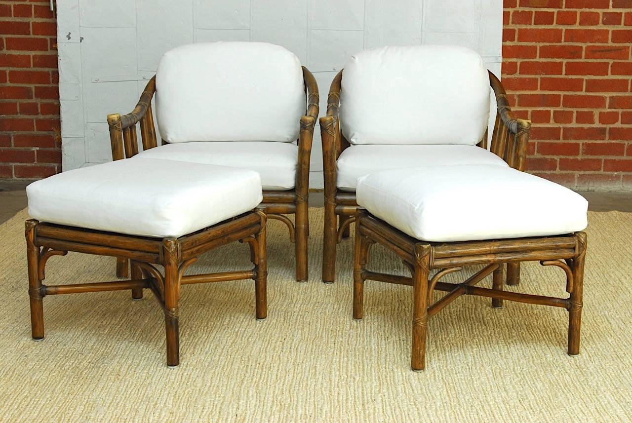 Impressive pair of McGuire bamboo rattan lounge chairs with ottomans. Hand-made organic modern design of rattan reinforced with leather strapping and end caps. Newly upholstered seat cushions and pads of organic cotton. Excellent joinery and seat