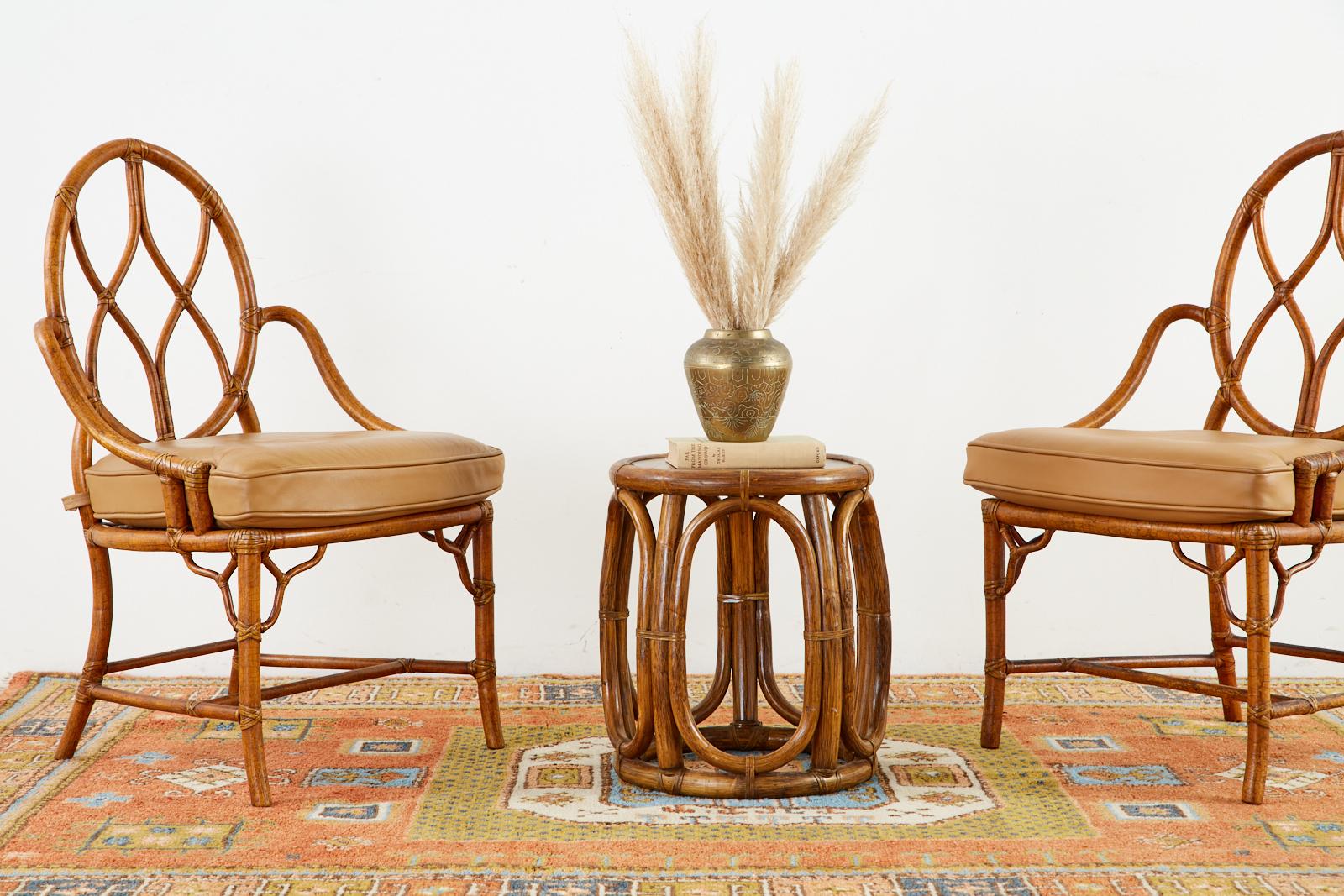 Rare pair of genuine McGuire garden stools or drinks tables having a drum form or tabouret style. Made in the California organic modern style from bent rattan poles lashed together with leather rawhide laces. Versatile little tables that can also be