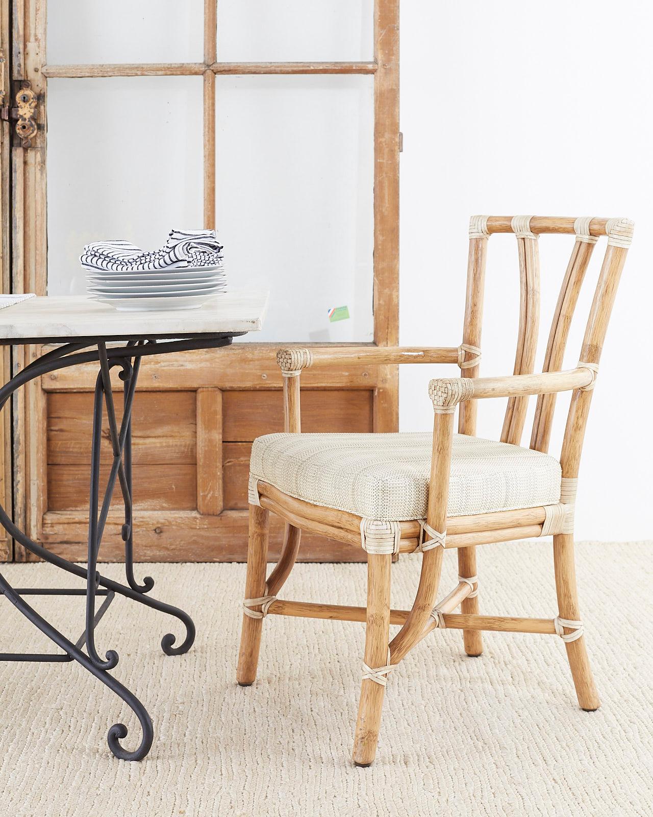 Stylish pair of genuine McGuire organic modern armchairs. Constructed from thick bamboo rattan poles with cream colored leather rawhide laces on the exposed joints. The chairs have an abundance of strapping which was more common on the mid to late