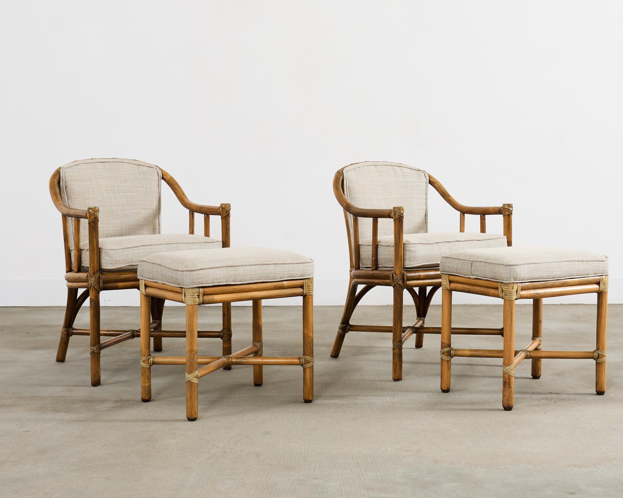 Mid-century modern pair of round back rattan armchairs with matching ottomans or footstools made in the California coastal organic modern style by McGuire artisans. The chairs feature a barrel back form constructed from bent pole rattan lashed