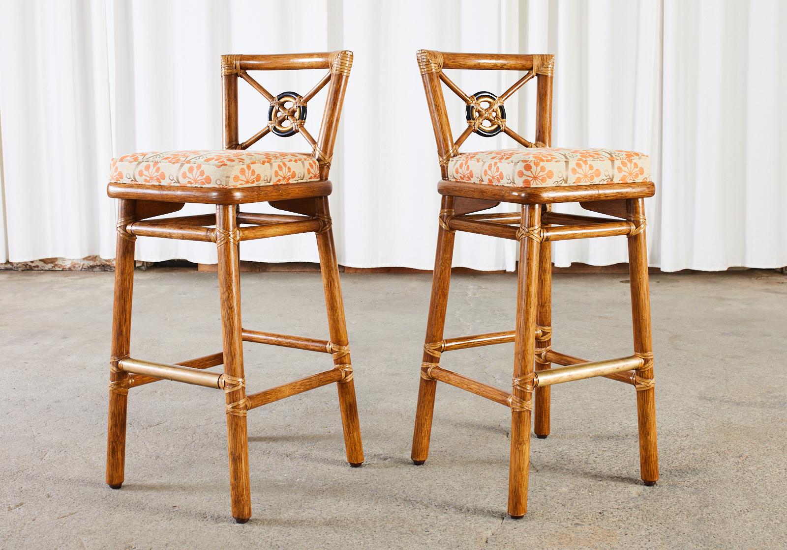Distinctive pair of rattan barstools made in the California organic modern style by McGuire. Known as target back stools designed by Elinor McGuire featuring the iconic target ring design with optional ring finishes in black and contrasting gilt.