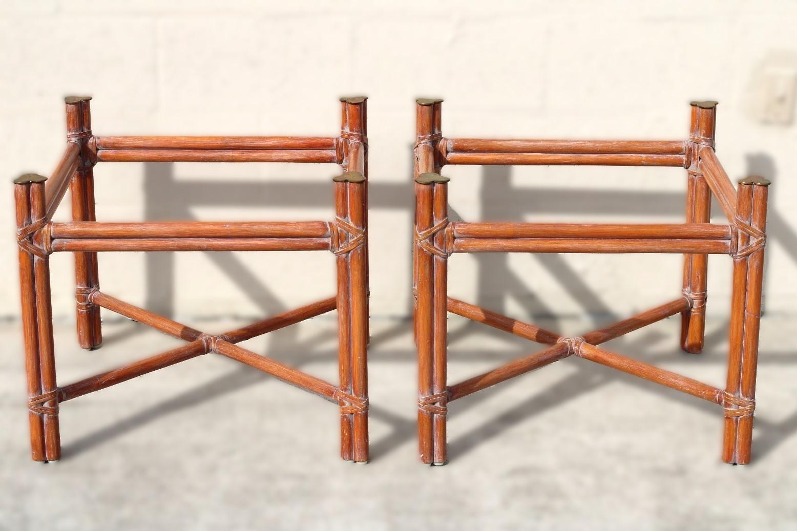 Pair of genuine McGuire organic modern rattan bamboo end tables. The square end tables or side tables feature a rattan frame with an x-base, trefoil brass leg caps and clear glass tops (included). The rattan frames are lashed together with McGuire's