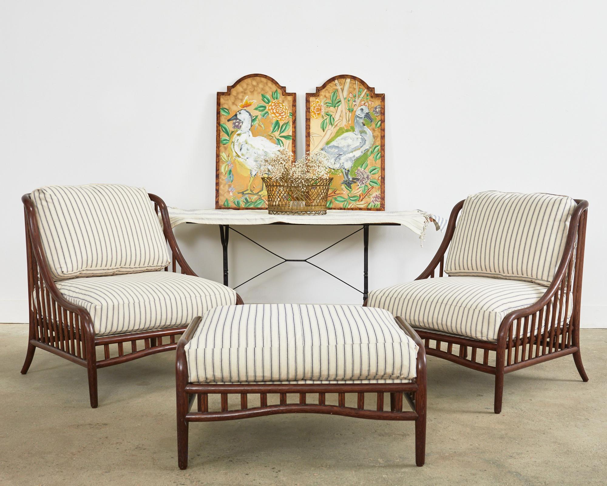 Exceptional pair of genuine McGuire rattan lounge chairs with a matching ottoman made in the California organic modern coastal style. The chairs feature thick pole rattan frames gracefully bent to form a continuous side and back. The bent rattan is