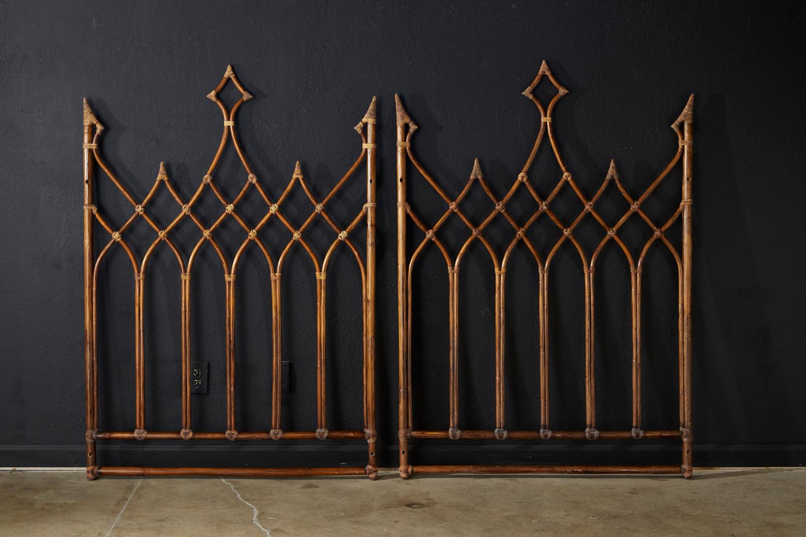 Distinctive pair of bamboo rattan twin headboards made by McGuire. Constructed form gracefully curved rattan poles having cathedral shaped arches in a gothic revival style. Lashed together with leather rawhide laces on the exposed joints. They