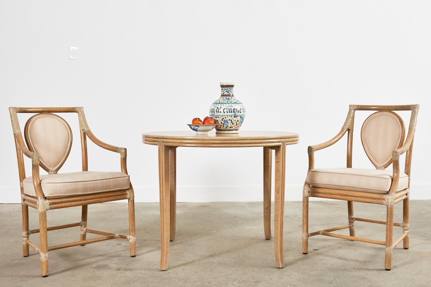 Elegante coppia di poltrone da pranzo con schienale ad anello in rattan McGuire, realizzate in stile moderno organico costiero californiano. Una delle sedie più iconiche e belle di McGuire, disegnata da Elinor McGuire negli anni Settanta. Le sedie