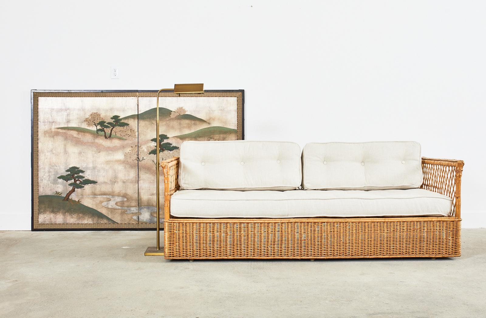 Amazing pair of organic modern coastal style case sofas, settees, or daybeds by McGuire. These rare and labor intensive sofas were only made for a short time by McGuire and feature an oak and rattan frame covered with woven wicker. Above the wicker