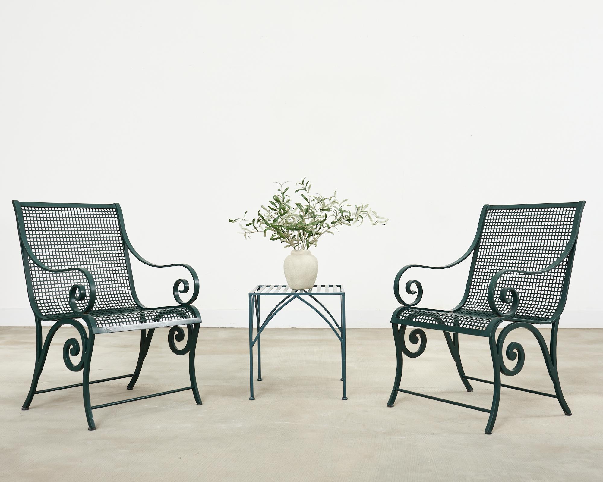 Whimsical labeled pair of McKinnon and Harris patio and garden lounge chairs or dining chairs. The chairs feature solid aluminum frames with gracefully scrolled arms and legs. The seat has a geometric mesh support with an ergonomic form. The frame