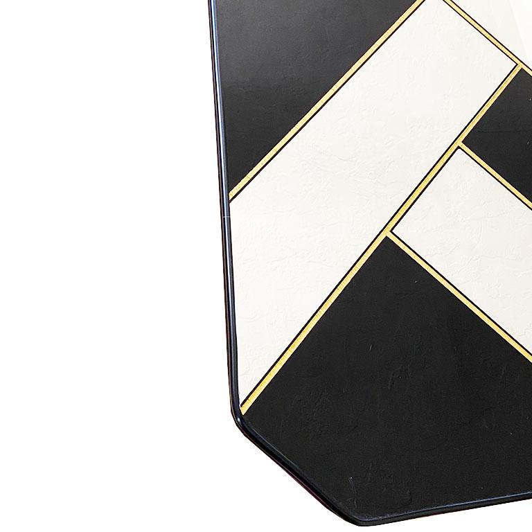 A pair of mirrored black and gold drink tables. In fabulous condition, the tops of these tables are geometric with four sides and clipped corners. The top of the tables are mirrored in a geometric pattern, with gold stripes around the edges. The
