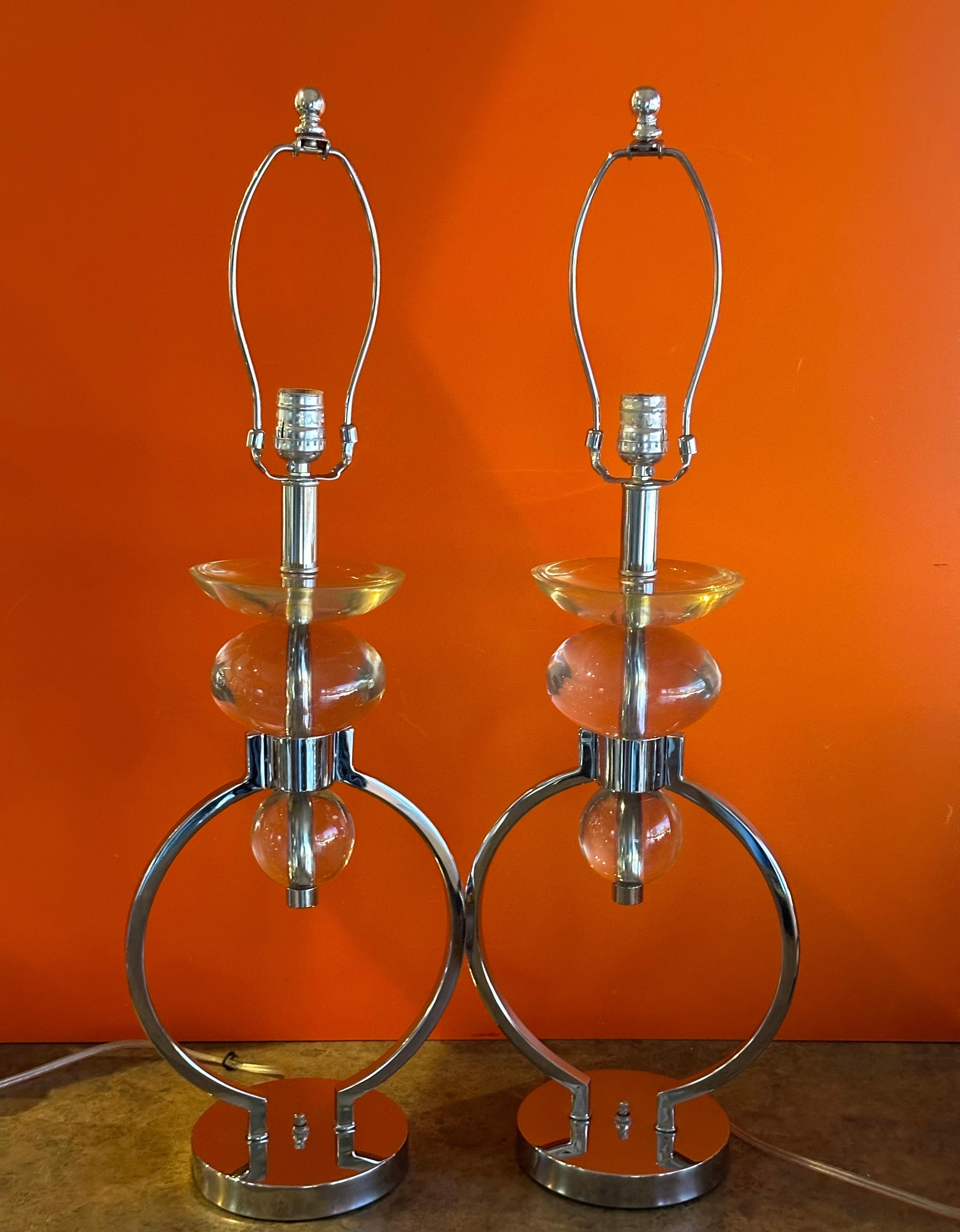 Precioso par de lámparas de sobremesa MCM de cromo y lucita de Hivo Van Teal, de la década de 1970. Estas preciosas lámparas están en muy buen estado y miden 9,5 cm de ancho x 6 cm de profundidad x 30 cm de altura.  La lucita es transparente y no